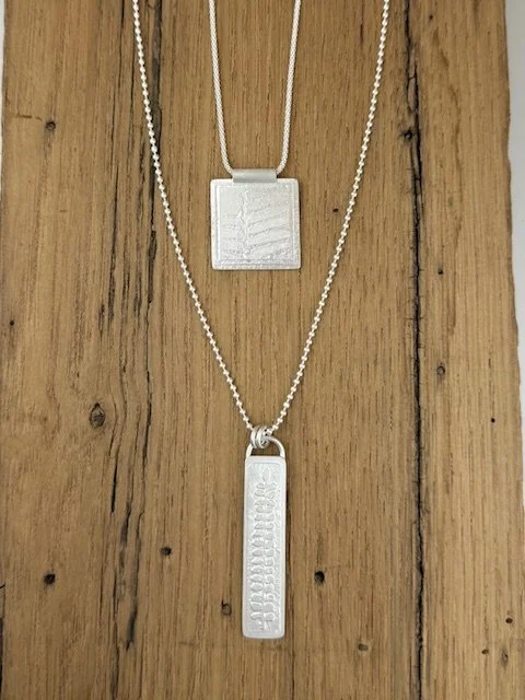 Artisan Botanica Collection by KFinn Designs, sterling silver square pendant necklace layered with long botanical-etched pendant.