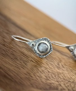 Close-up of Mini Opulence Earrings handcrafted in textured sterling silver with rose-cut silver sapphire and faceted accent stone