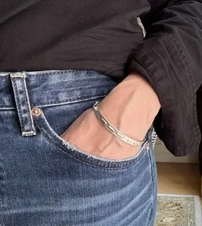 Love Note bracelet worn with hand in pocket.jpeg
