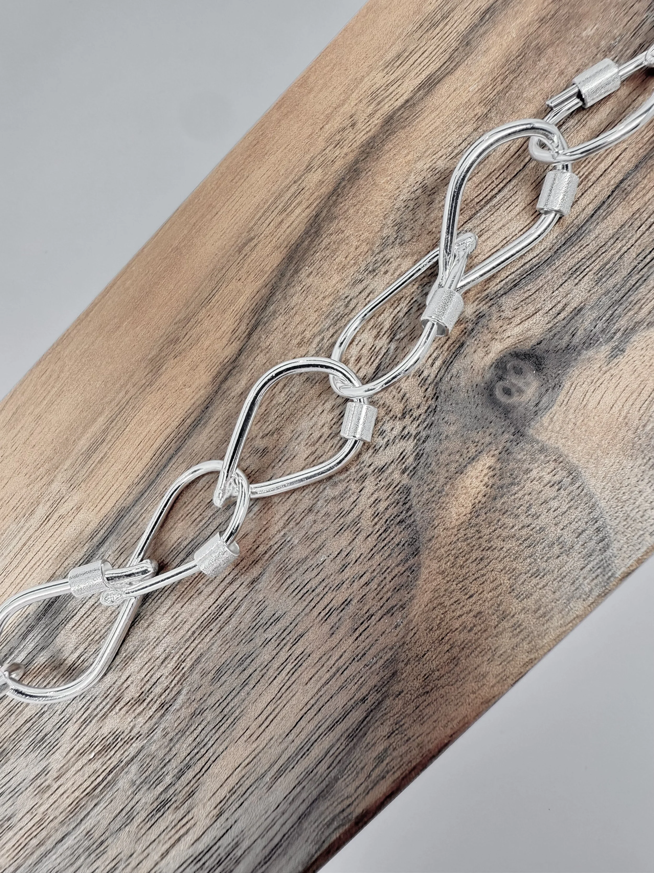 Close-up of KFinn Designs Droplet Link Necklace showing smooth sculptural silver droplet links with artisanal texture