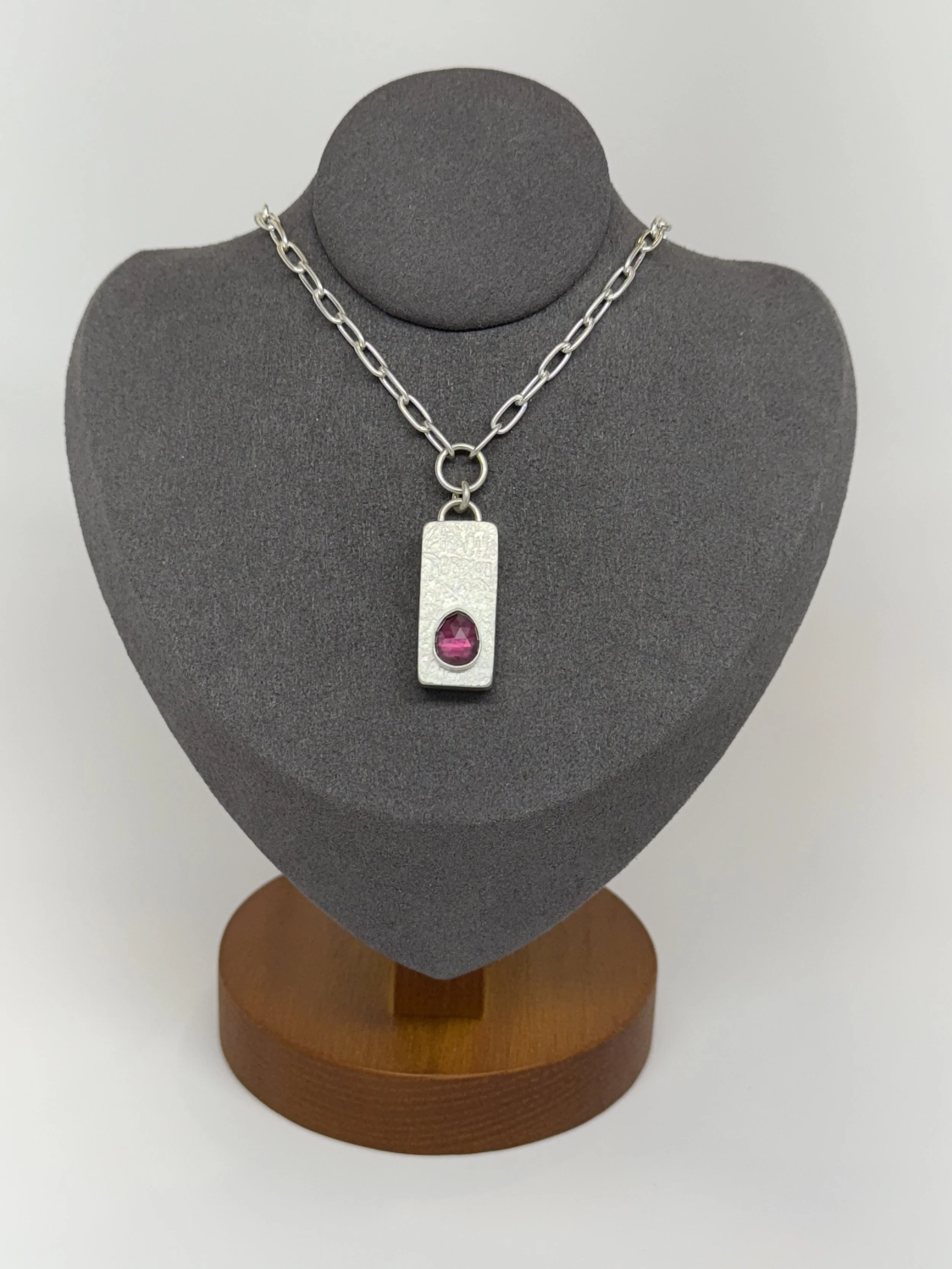 Keystone-Pendant-kfinndesigns-rhodolite-garnet-on-gray-stand.jpg