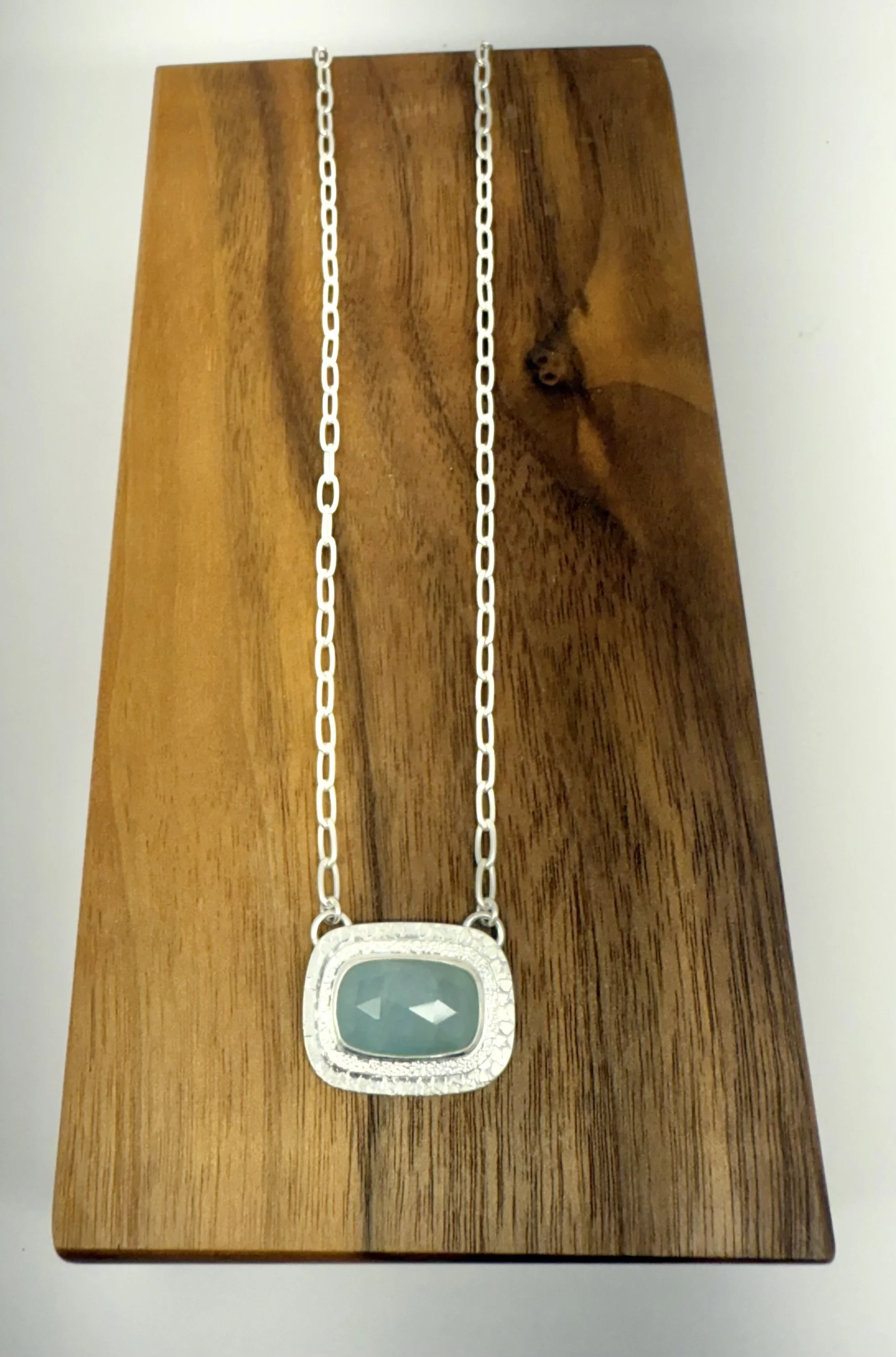 Portal Pendant Aquamarine lying flat on wood.jpg