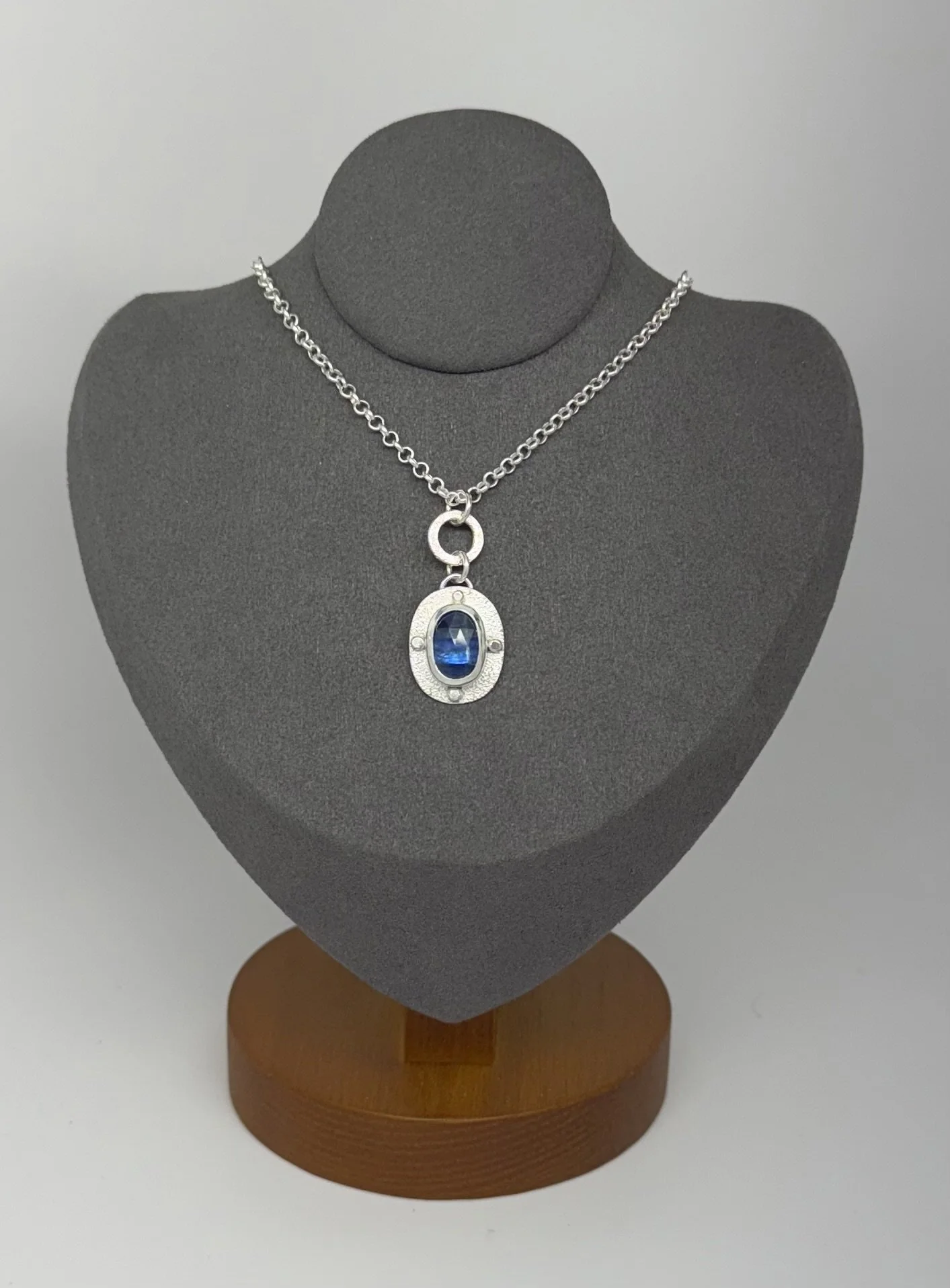 Modern Relic oval kyanite pendant on gray stand.jpg