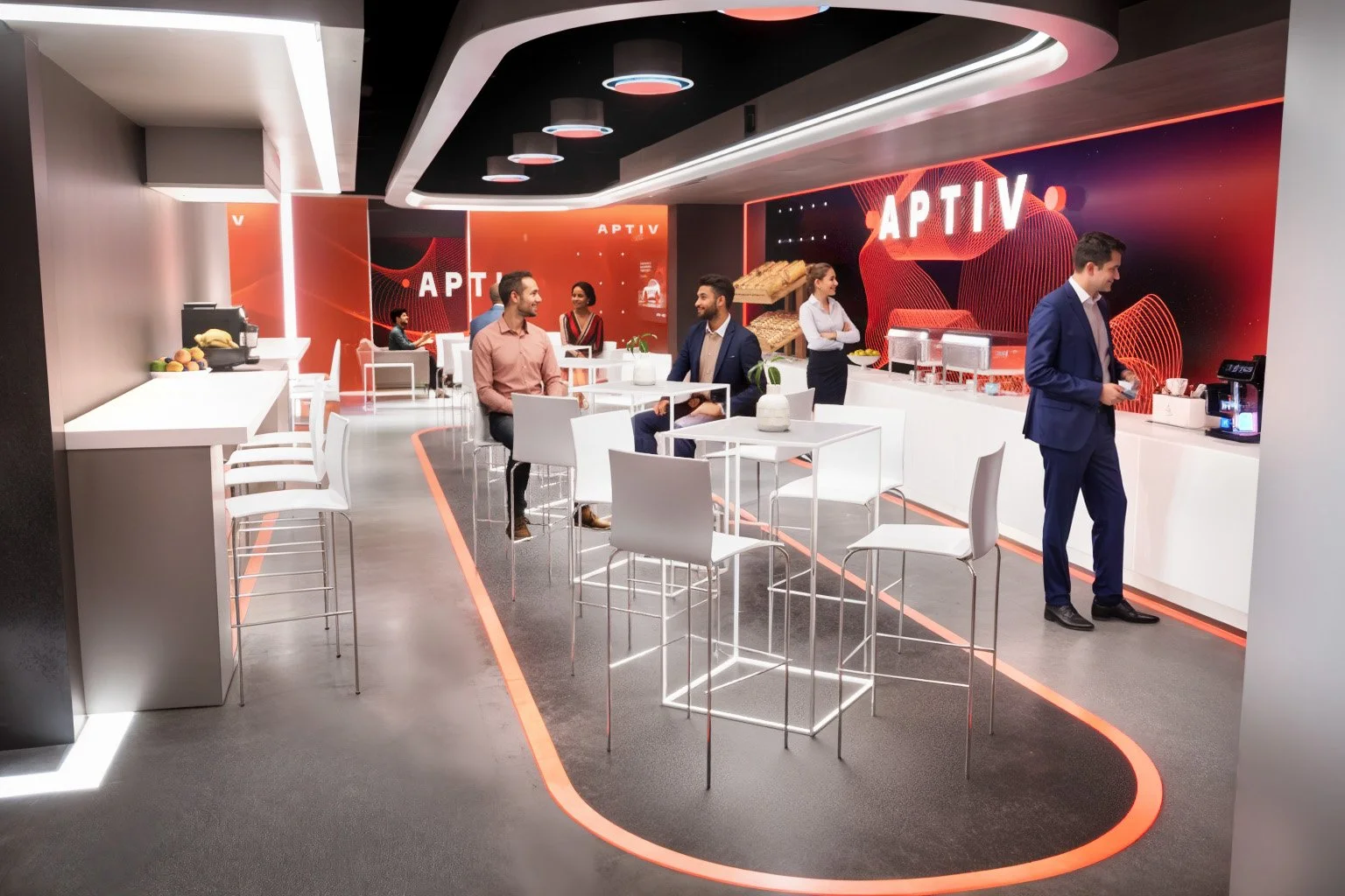 Modern indoor lounge area with white tables and chairs, some people sitting and talking, a man at a counter with a coffee machine, red and black walls with illuminated signs saying 'APTIV', and contemporary lighting fixtures.