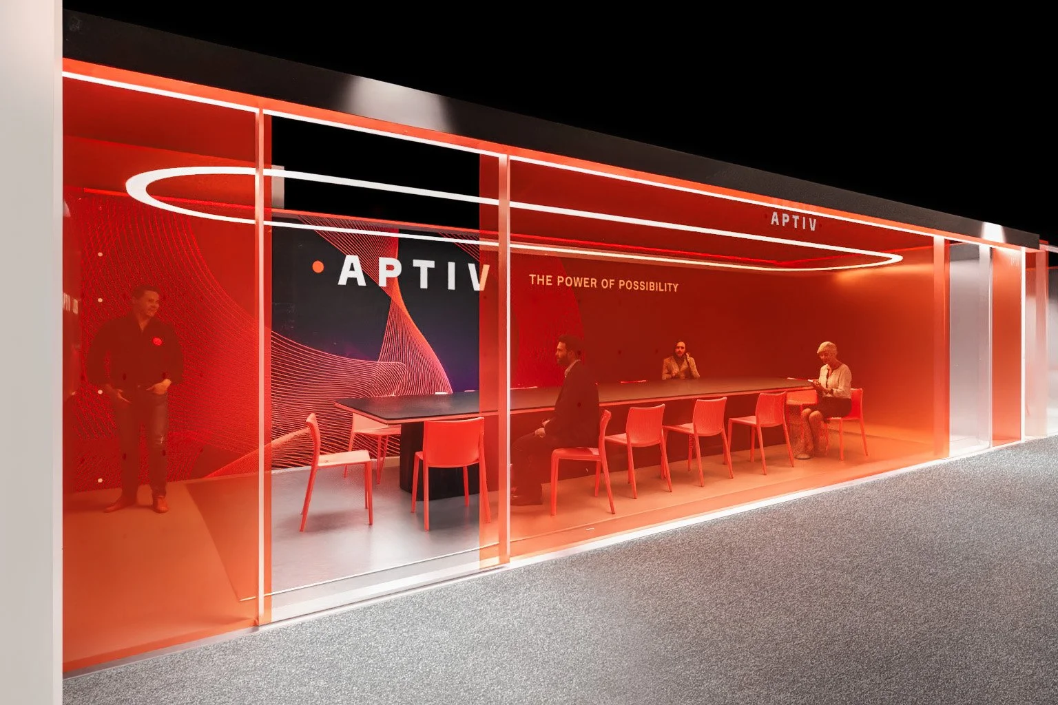 Modern glass-walled conference room with red orange lighting, seating, and a large digital display reading 'APTIV' with the slogan 'The Power of Possibility'.