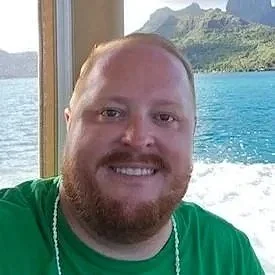 Smiling headshot of a bearded man