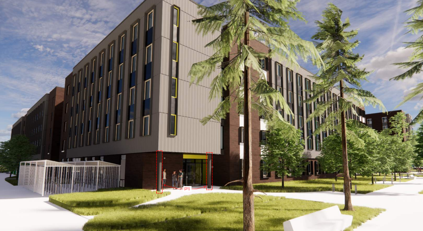 A modern multi-story building with black and brown exterior, large windows, and a green grass lawn in the foreground. There are trees and a pathway in front of the building, with a small group of people near the entrance.