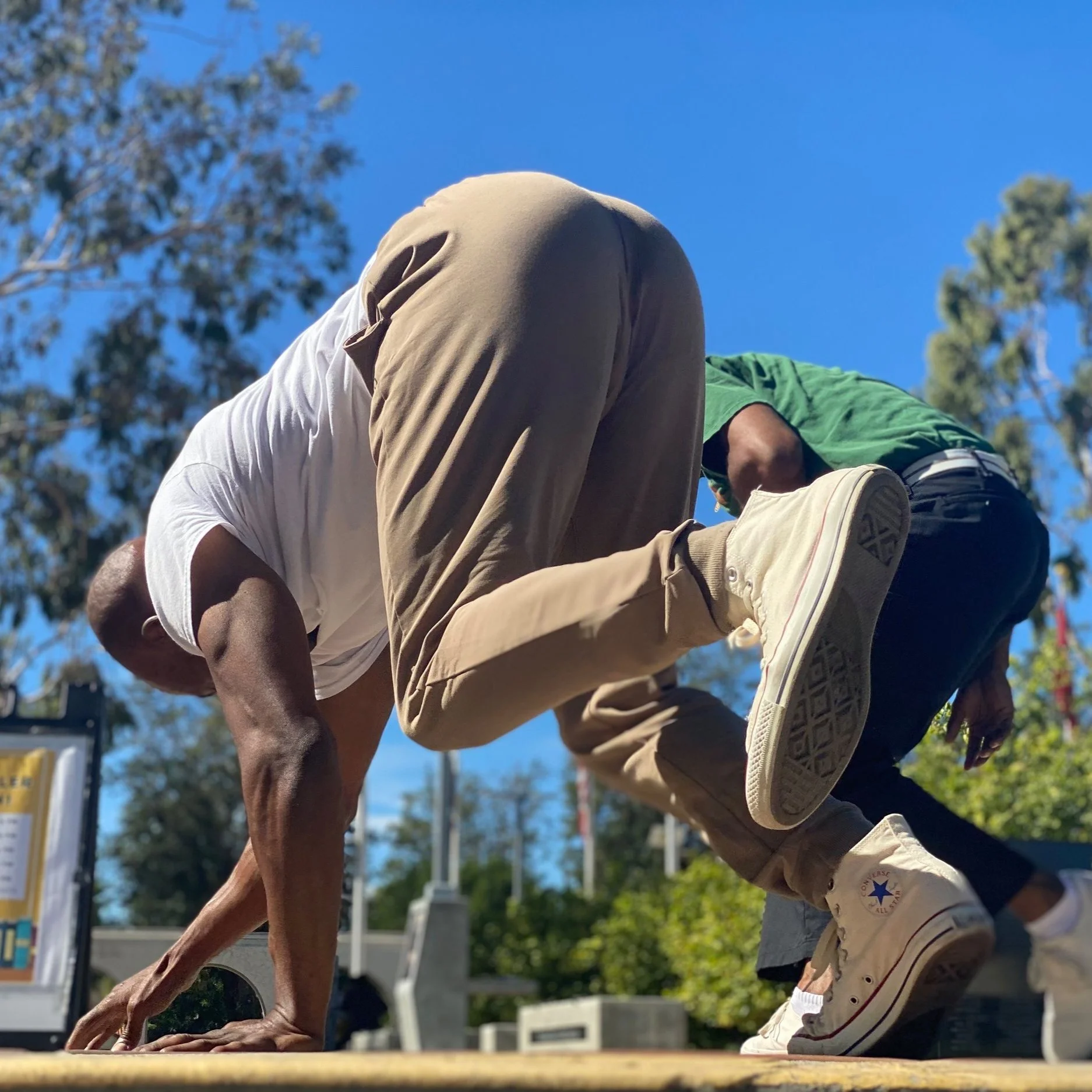 Two men engage in a display of Capoeira de Angola in the outdoors during a roda in Southern California. 