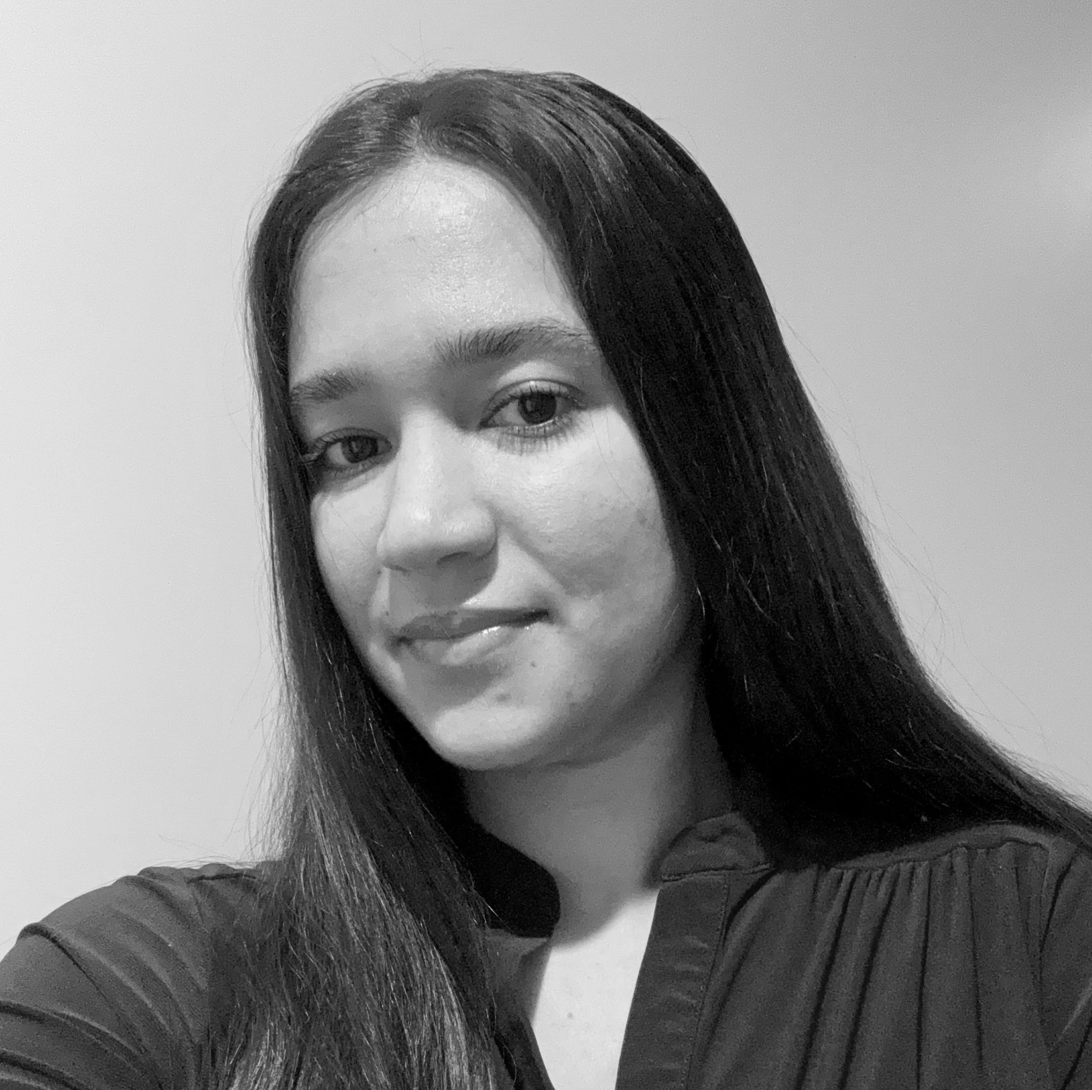 Black and white portrait of a woman with long hair smiling gently at the camera.