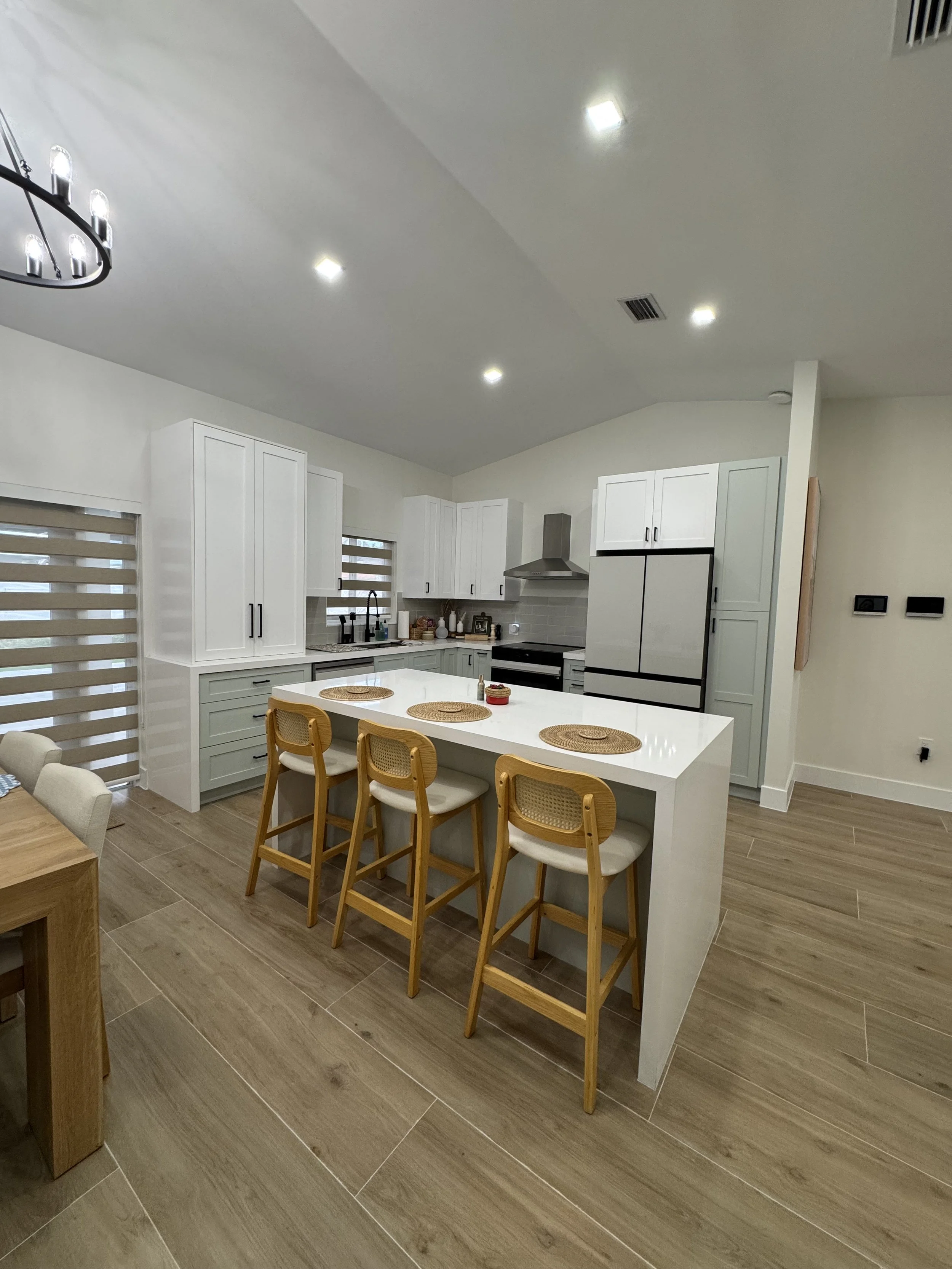 shaker kitchen with white cabinets, a large island.