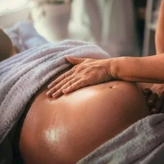 Close-up of a person giving a massage on their abdomen.