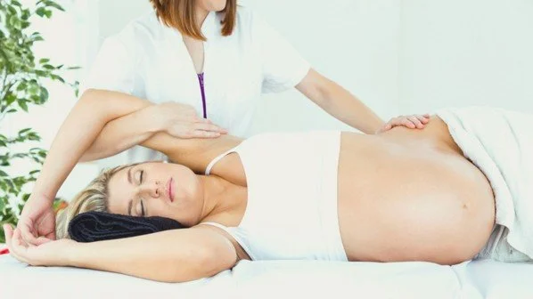 pregnant client lying comfortably on their side for a prenatal massage