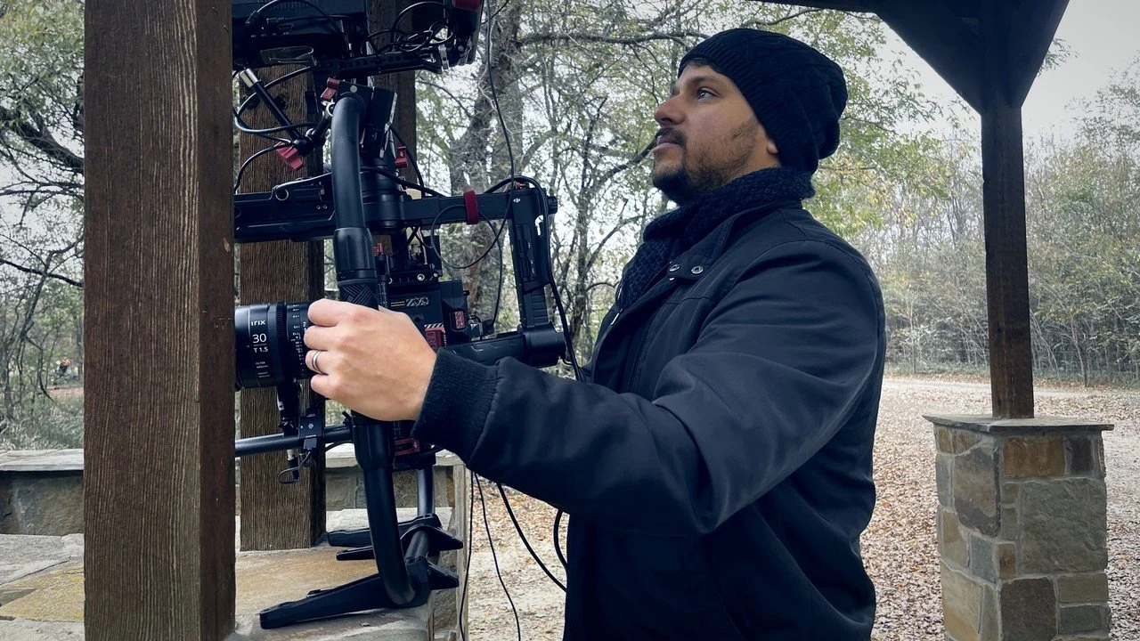 Alex directing talent beside camera on a Dallas commercial set