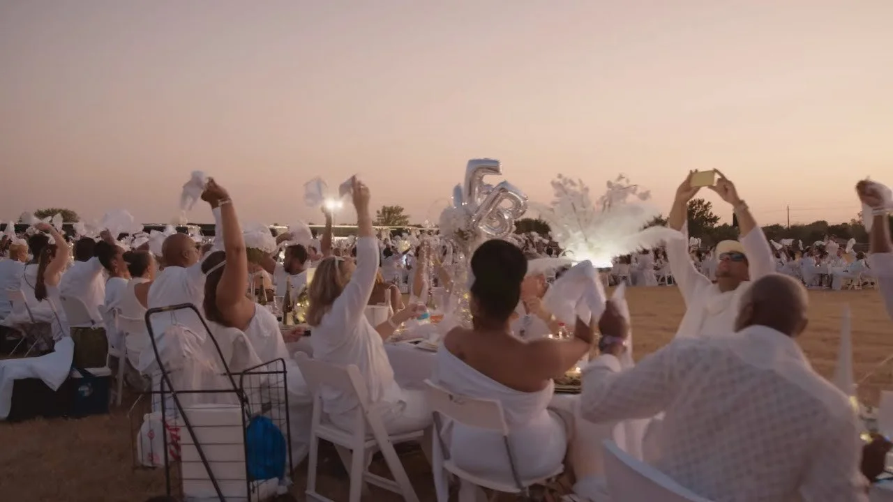 Guests waving white napkins at Le Diner en Blanc Dallas, filmed by Dallas event videographer Alex Kinter