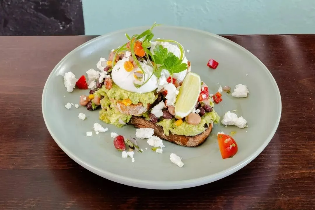 The brunch classic, done our way - smashed avo with poached eggs, charred corn salsa, cherry tomatoes, feta, and a squeeze of lime on toasted sourdough.