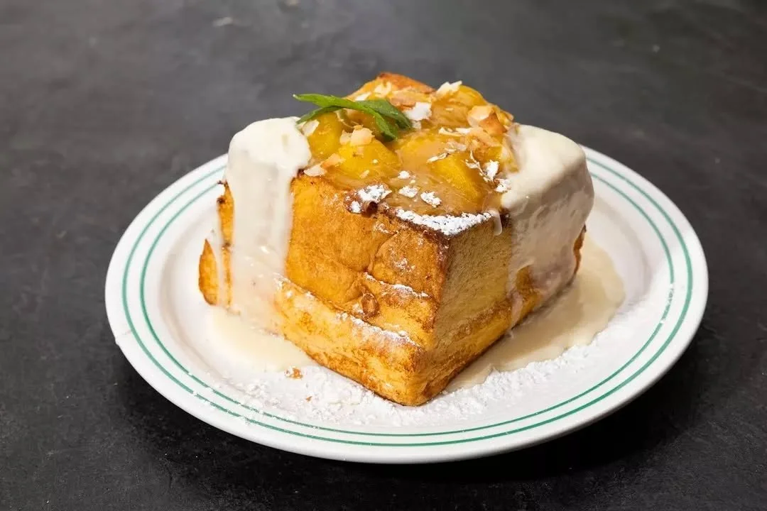 Crispy on the outside, soft and oozing on the inside. 🤤 Our coconut and mango French toast is layered with spiced mango jam, white chocolate crema, coconut custard, and finished with toasted coconut - a slice of tropical heaven.