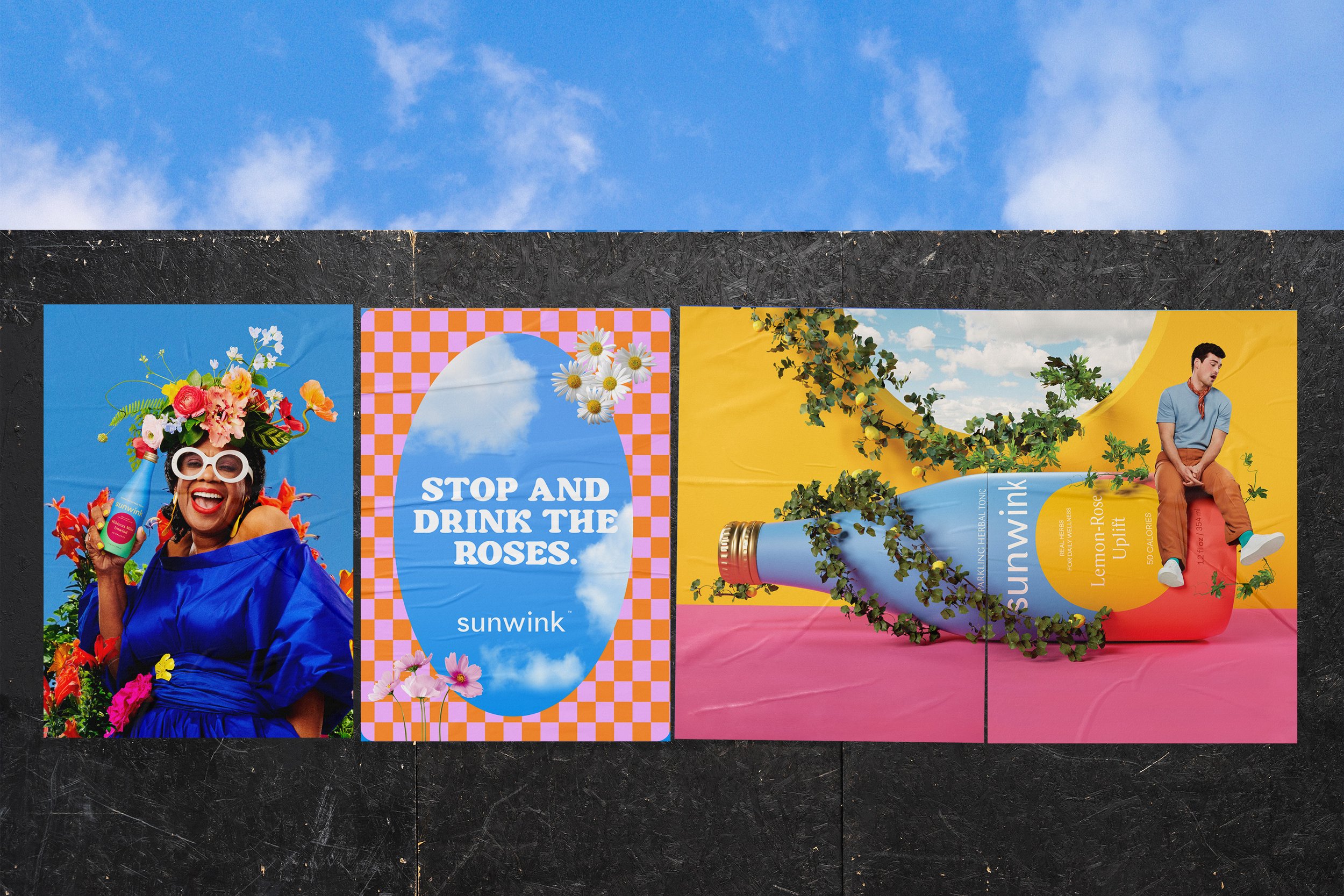 Three Sunwink advertisement posters on a black surface. The first features a woman with colorful flowers on her head holding Sunwink drinks, smiling with sunglasses. The second is an advertisement with the text 'Stop and drink the roses' with a blue sky background. The third features a man sitting beside a large bottle of Sunwink Lemon-Rose flavor, with green vines growing from the bottle against a colorful backdrop.