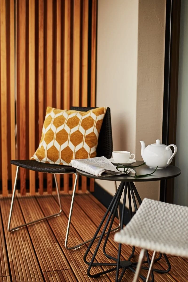 Privater Holzbalkon eines Zimmers im Boutique Hotel Winterfeld mit Design-Möbeln und Kaffeegedeck für erholsame Stunden in Bodenmais