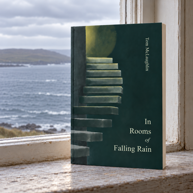 Book titled “In Rooms of Falling Rain” by Tom McLaughlin standing on a weathered windowsill overlooking a cloudy ocean and rocky coastline.