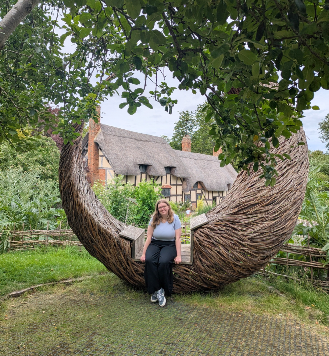 Amy Laughlin sits in front of Anne Hathaway's thatched cottage