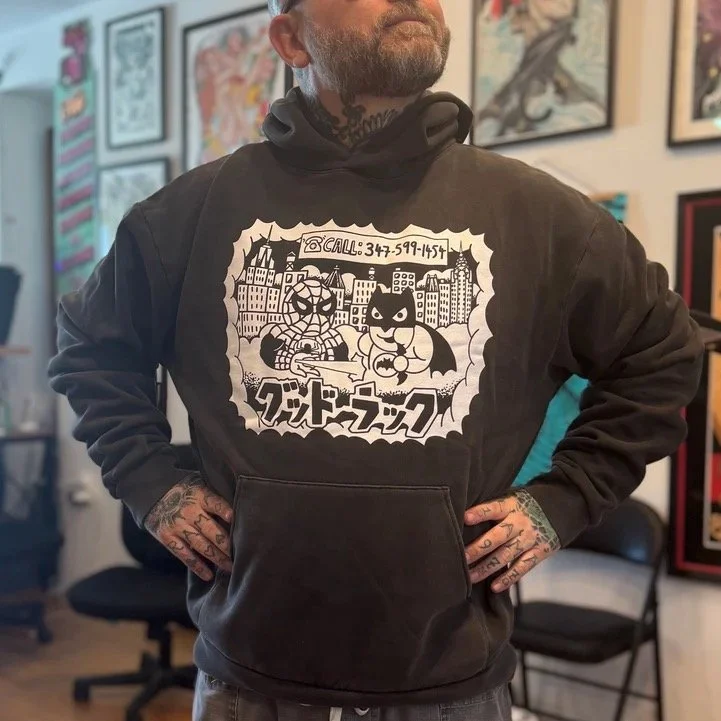 Super Heavyweight Hoodie GOOD LUCK NYC ''Heroes for hire'' by Kiku/Henbo, in Vintage Black print is in white. 

This Independent 420gm heavyweight garment is made from carefully selected yarns for a durable dry hand feel. This hoodie has an oversized