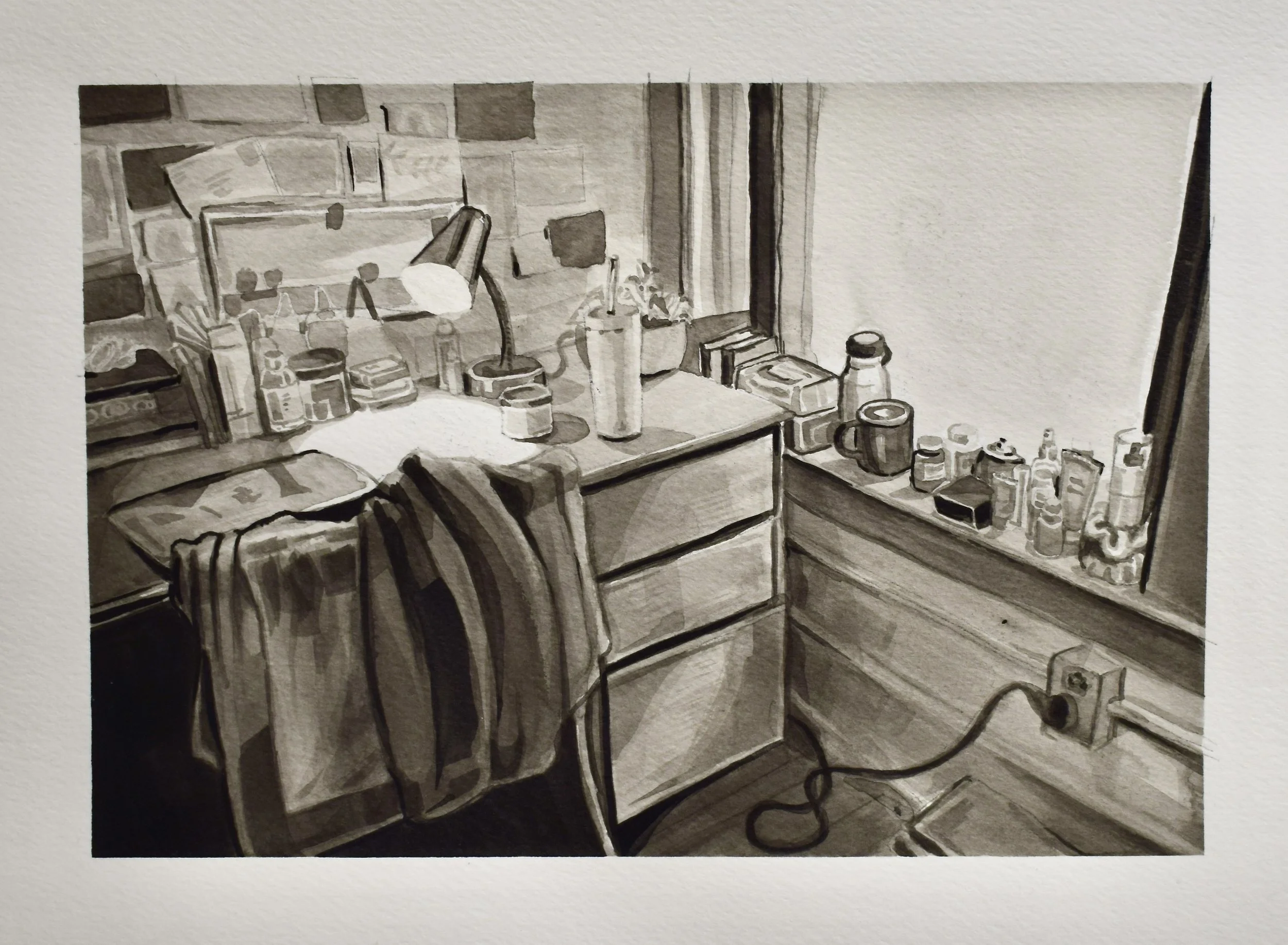A black and white photograph of a cluttered desk with various bottles, cans, and papers, a lamp, a hoodie draped over the edge, and a window in the background with a window sill holding more bottles and containers.