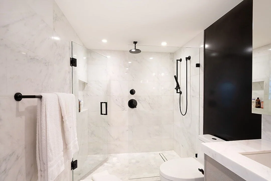 CRISP &amp; CLEAN⁣
That&rsquo;s how I like my bathrooms - how about you? This bathroom was all about luxury with wall to wall marble tile and custom blackened steel wall panels. To balance the stark contrast of the black and whites, a white oak vanit