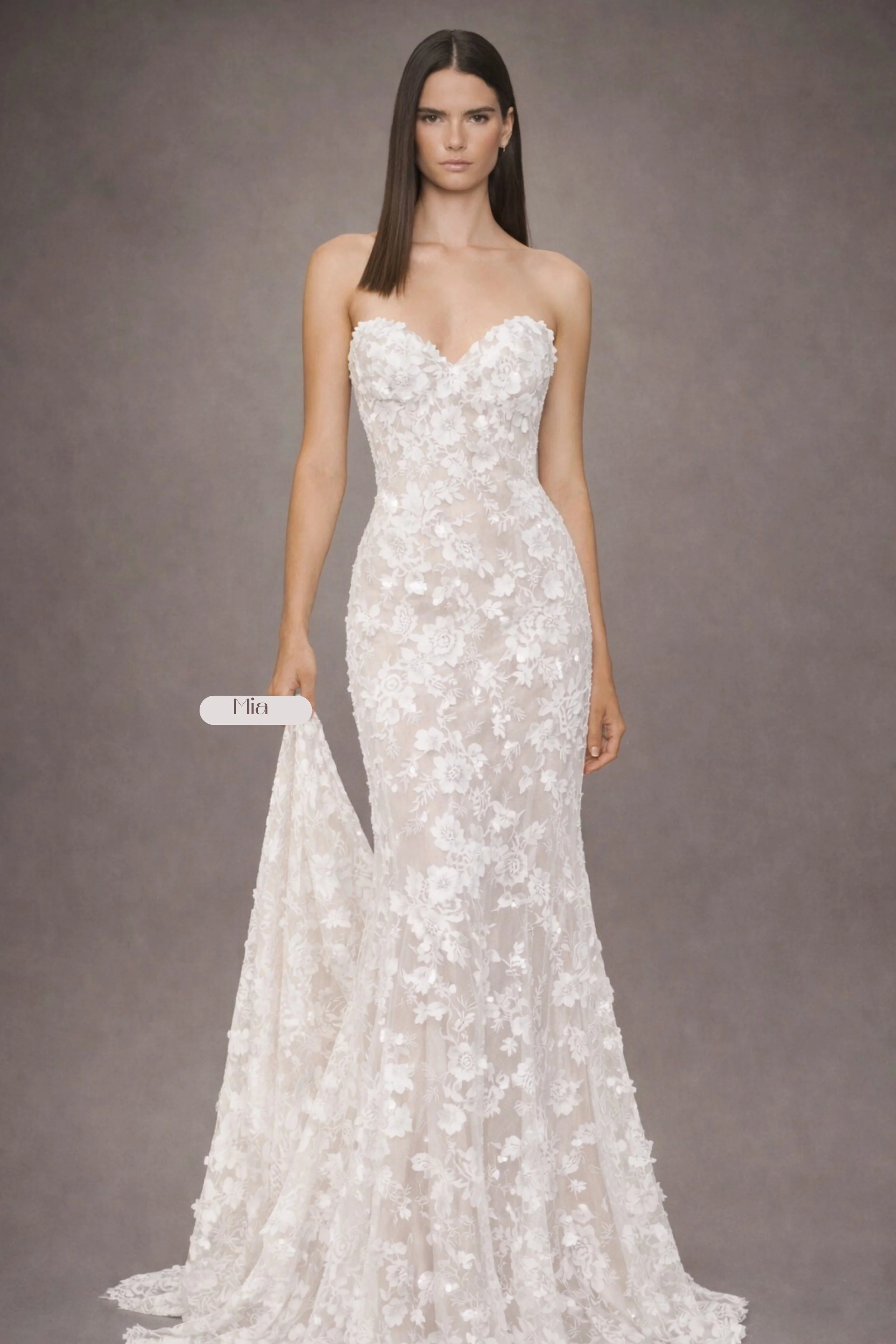Strapless lace mermaid wedding dress with floral appliqué, sheer bodice, and long train back view