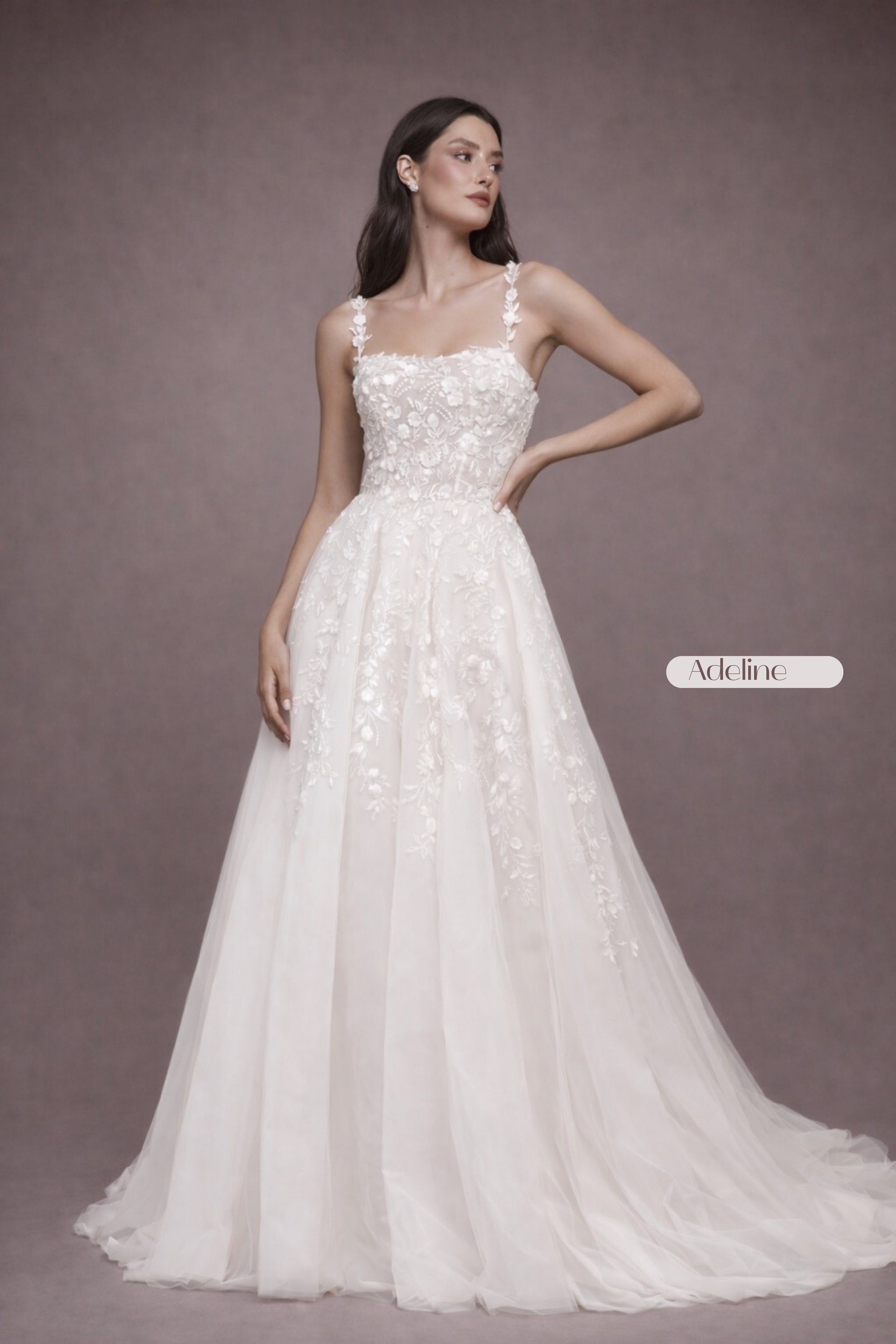 Square neck lace wedding dress with floral lace straps, illusion bodice, open back, and flowing tulle A-line skirt for a romantic, modern bridal look. Akmaral Bridal