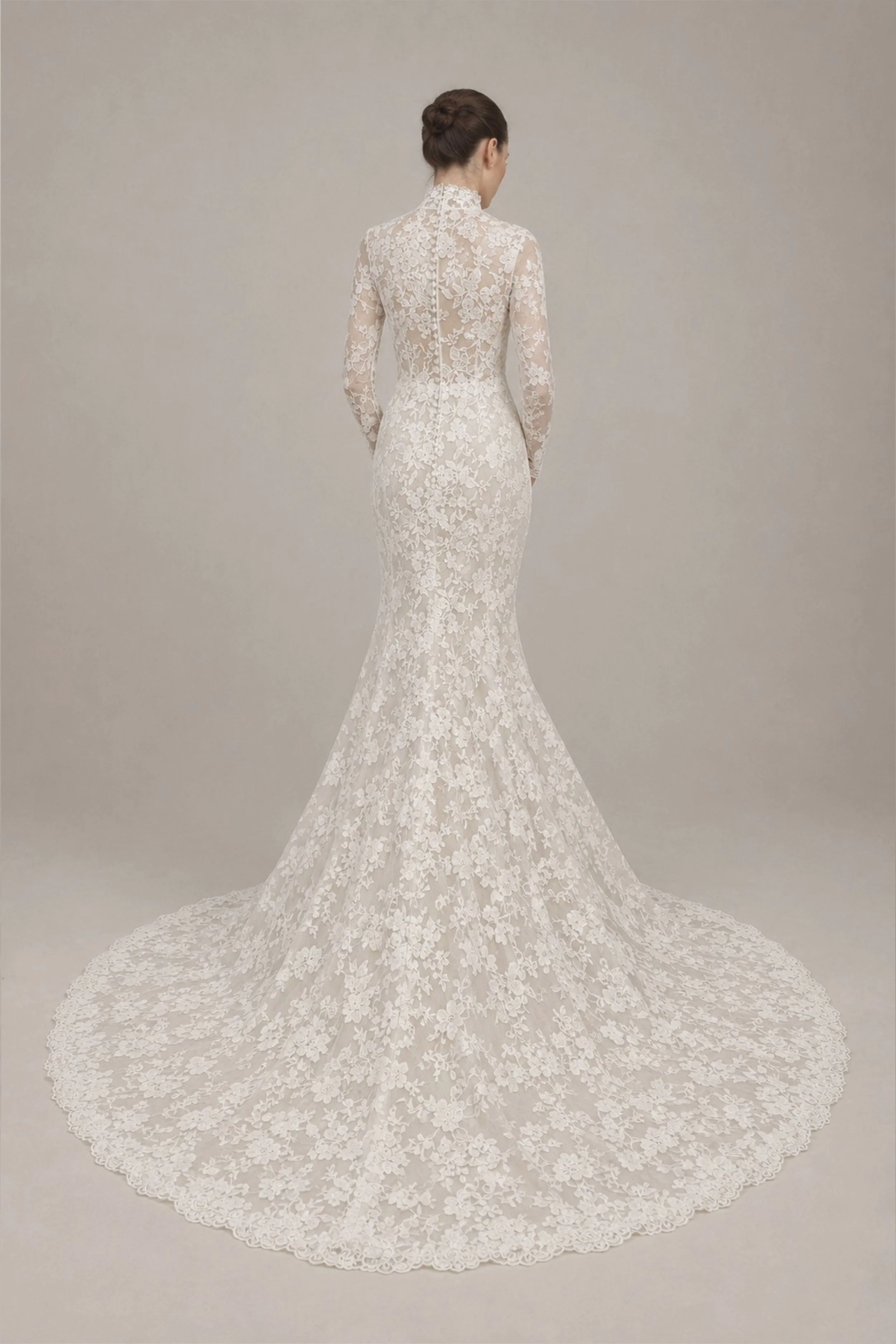 High neck long sleeve lace wedding dress with a closed back, fitted mermaid silhouette, floral lace, cathedral train, and sheer sleeves.