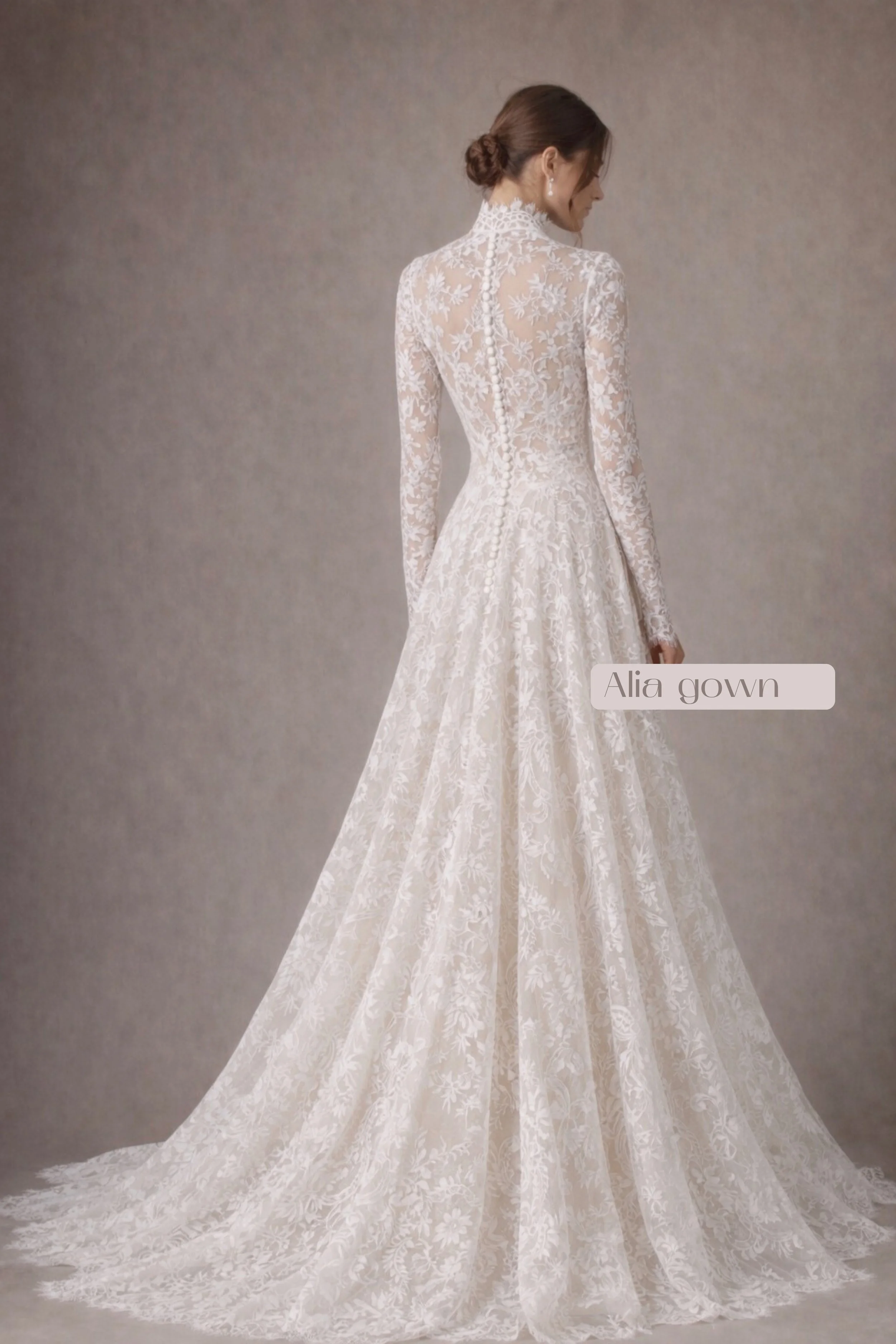 Long-sleeve lace wedding dress with high neckline, button-back bodice, and flowing A-line skirt