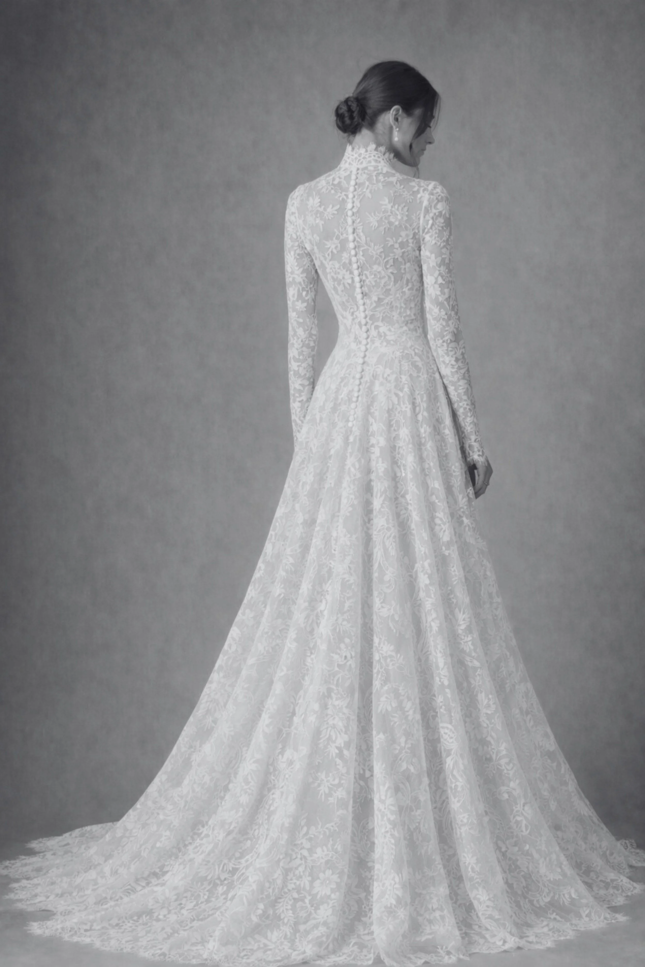 Long-sleeve lace wedding dress with high neckline, button-back bodice, and flowing A-line skirt