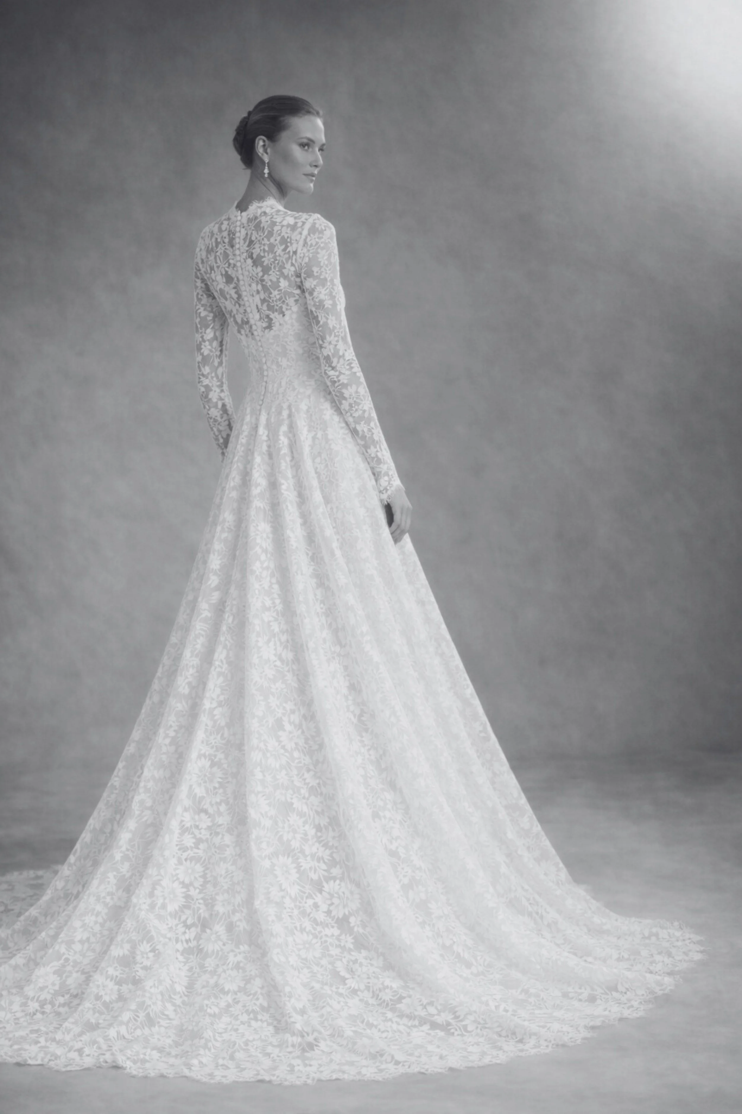 Long sleeve lace wedding dress with V-neckline, fitted bodice, flowing A-line skirt, and lace veil