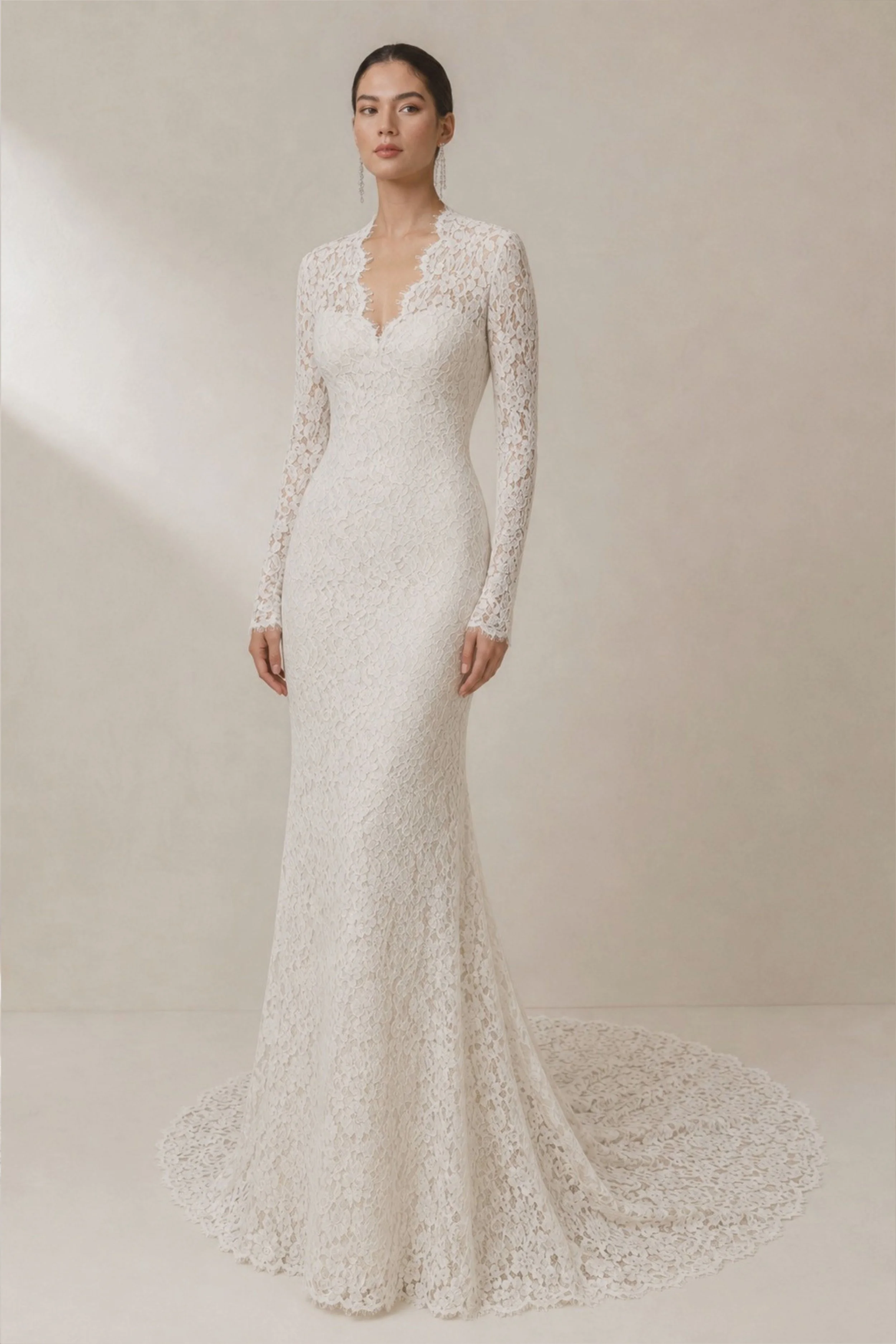 Long sleeve Chantilly lace sheath wedding dress with a V neckline, modest silhouette, cathedral train, and timeless elegance for a modern bride.