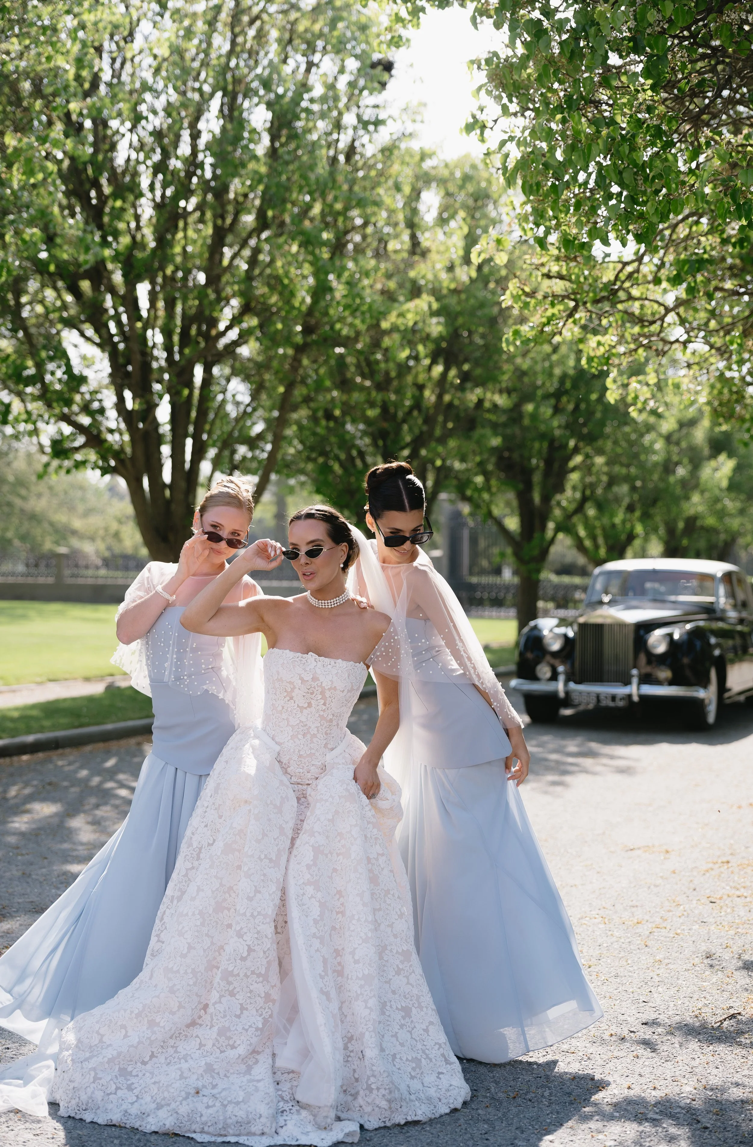 Convertible strapless lace wedding dress with a fitted sheath silhouette, detachable A-line overskirt, floral lace, and cathedral train.