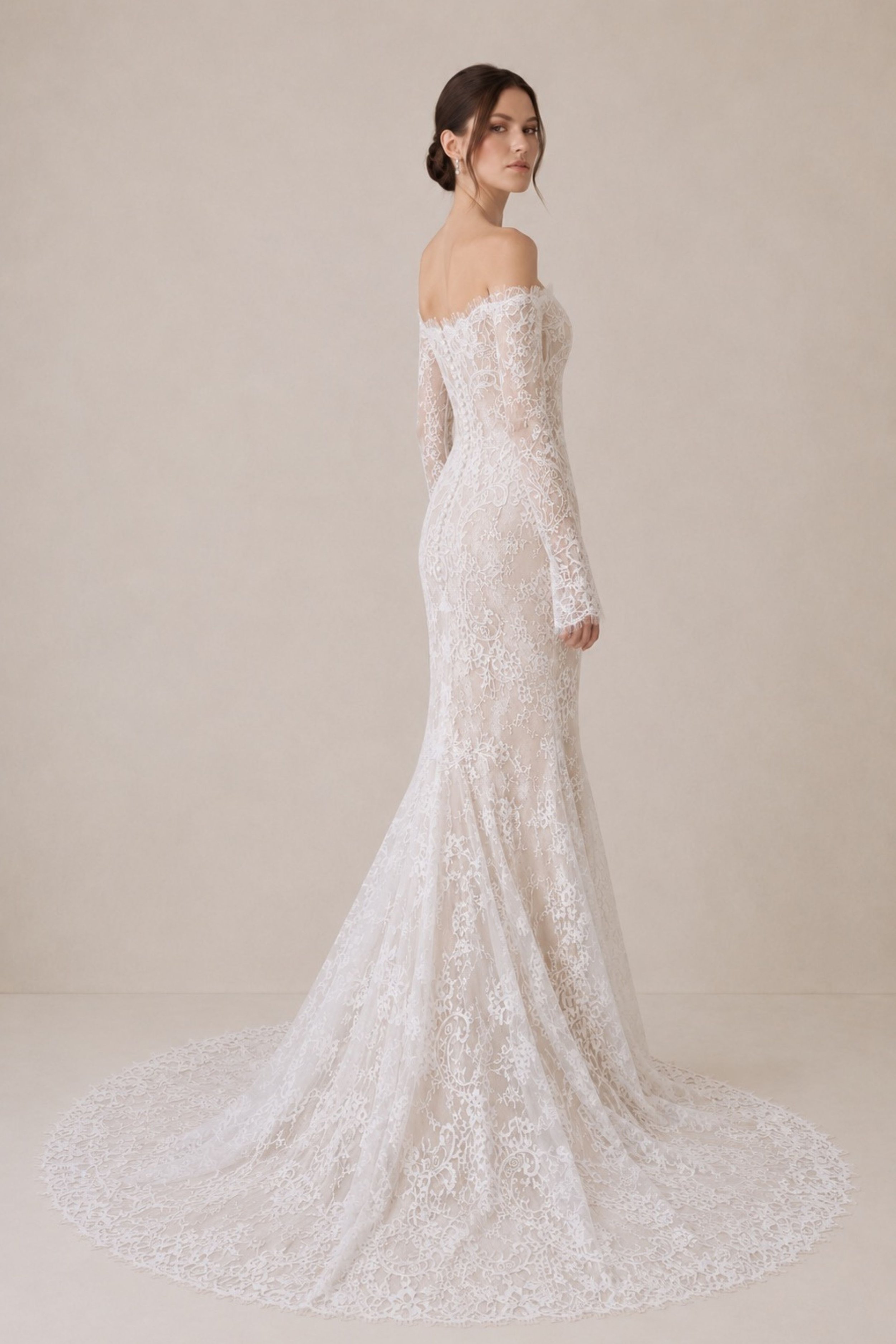 Off-the-shoulder Chantilly lace wedding dress with illusion long sleeves, fitted mermaid silhouette and scalloped train for a modern bride.