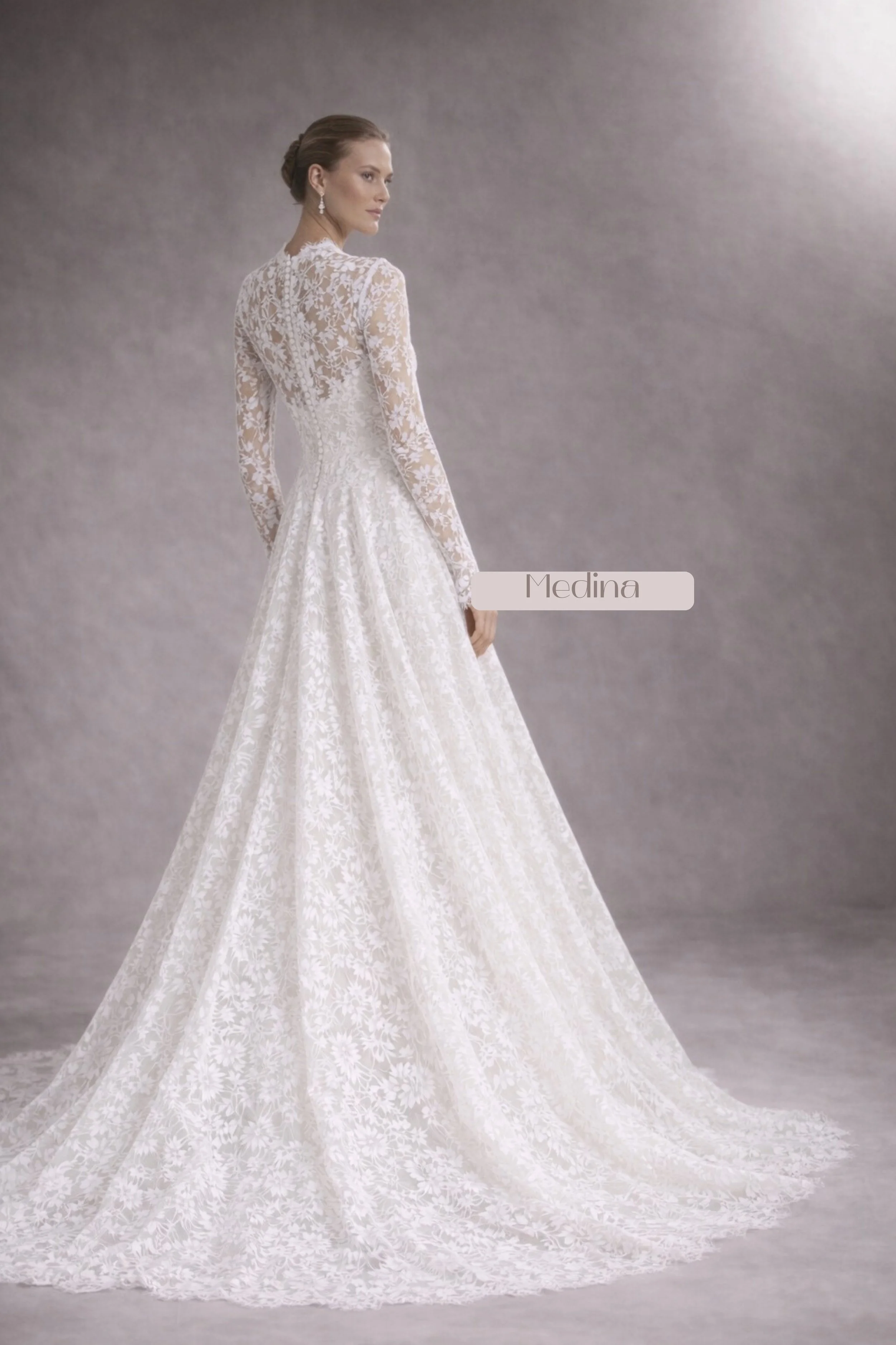 Long sleeve lace wedding dress with V-neckline, fitted bodice, flowing A-line skirt, and lace veil