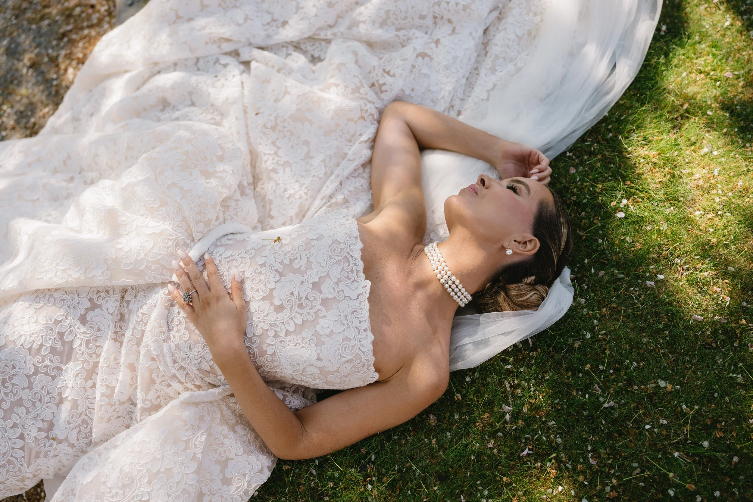 Convertible strapless lace wedding dress with a fitted sheath silhouette, detachable A-line overskirt, floral lace, and cathedral train.