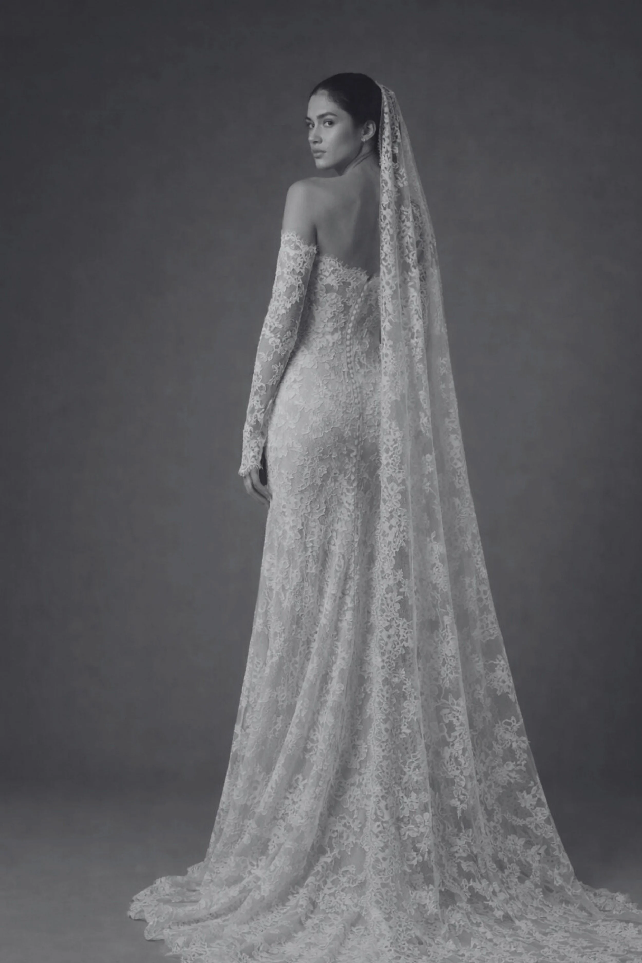 Long sleeve lace wedding dress with strapless neckline and veil, perfect for a classic church bride