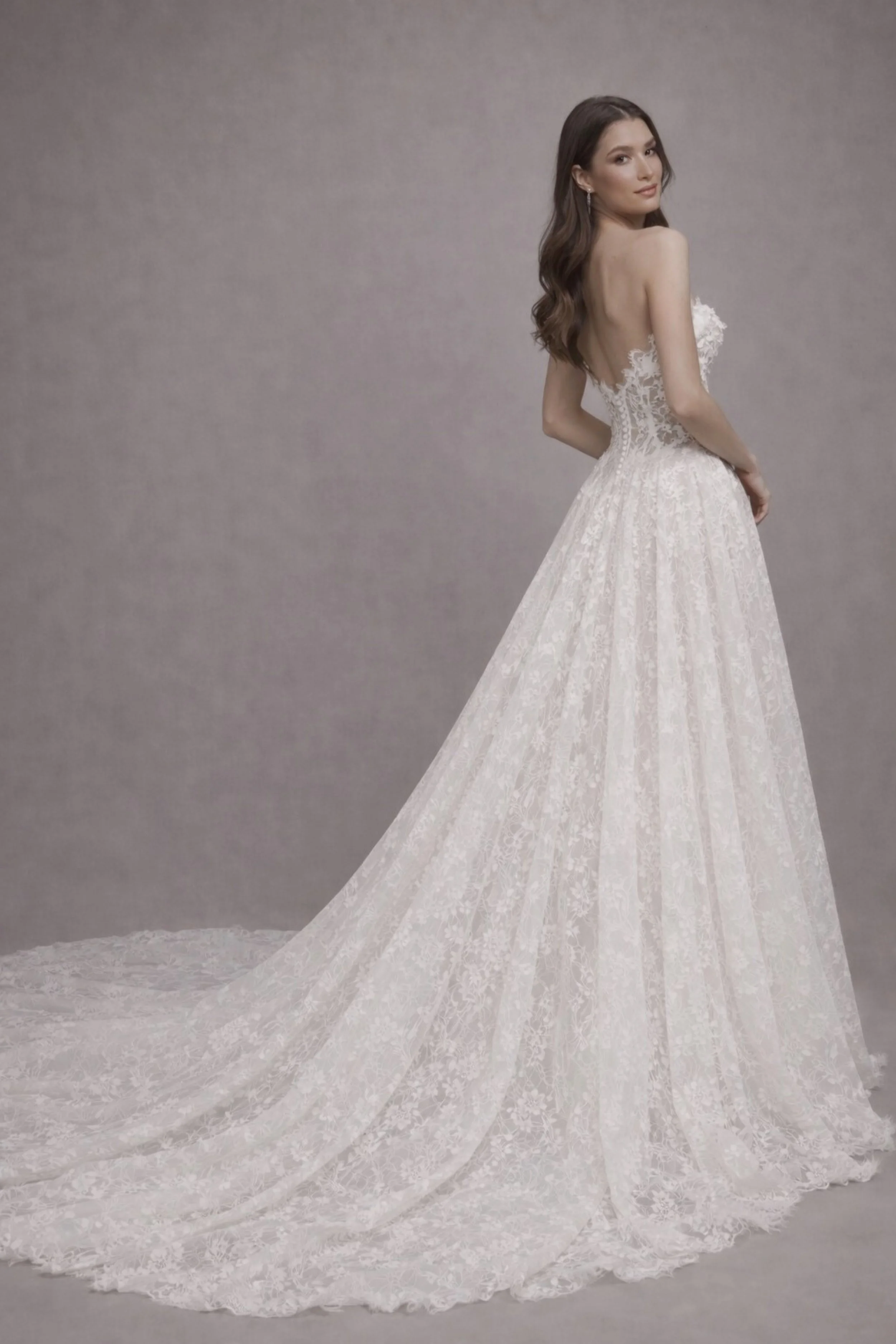 Open back lace A-line wedding dress with floral details and flowing train, romantic bridal gown