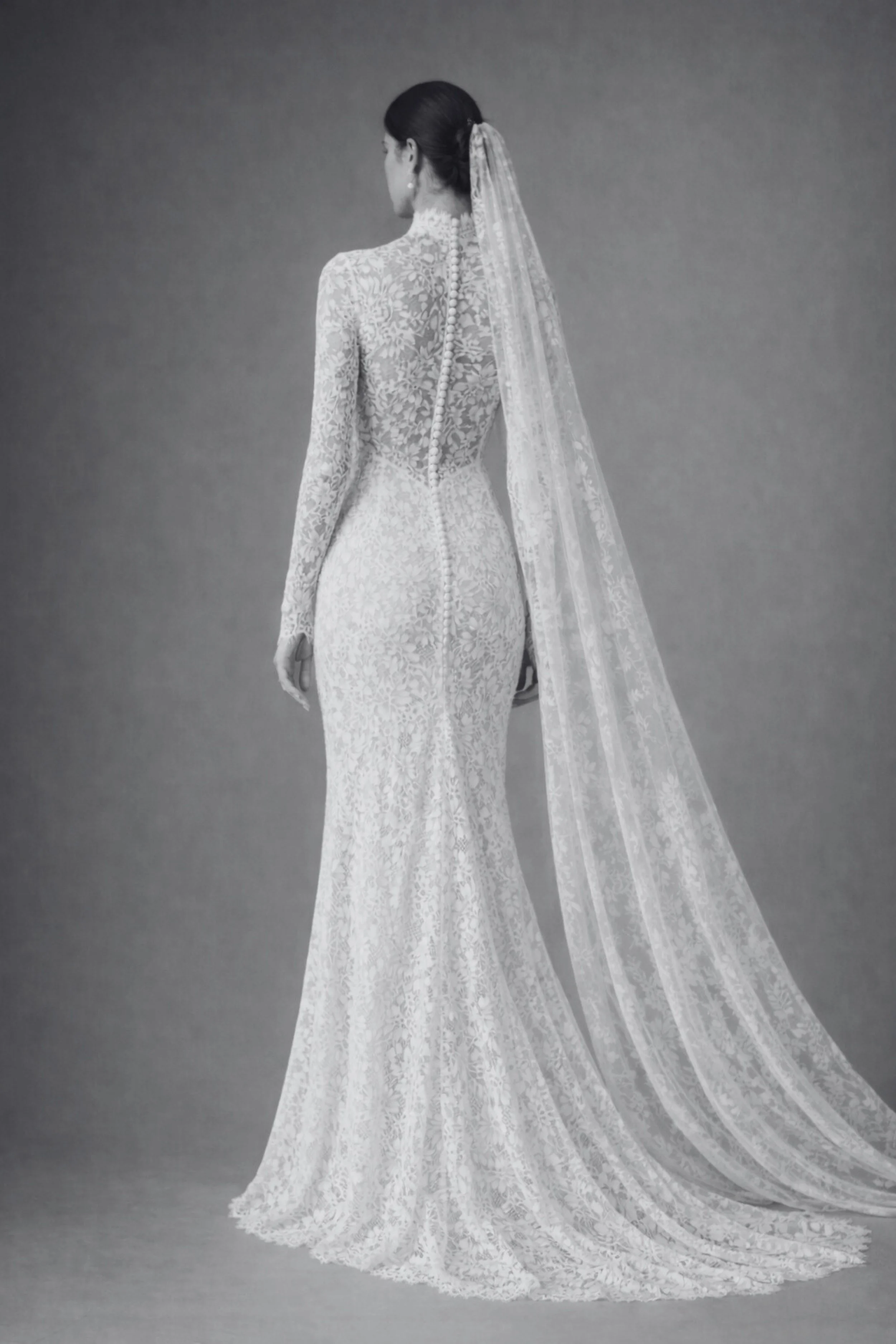 Back view of lace bridal gown with long sleeves, high neck, covered buttons.