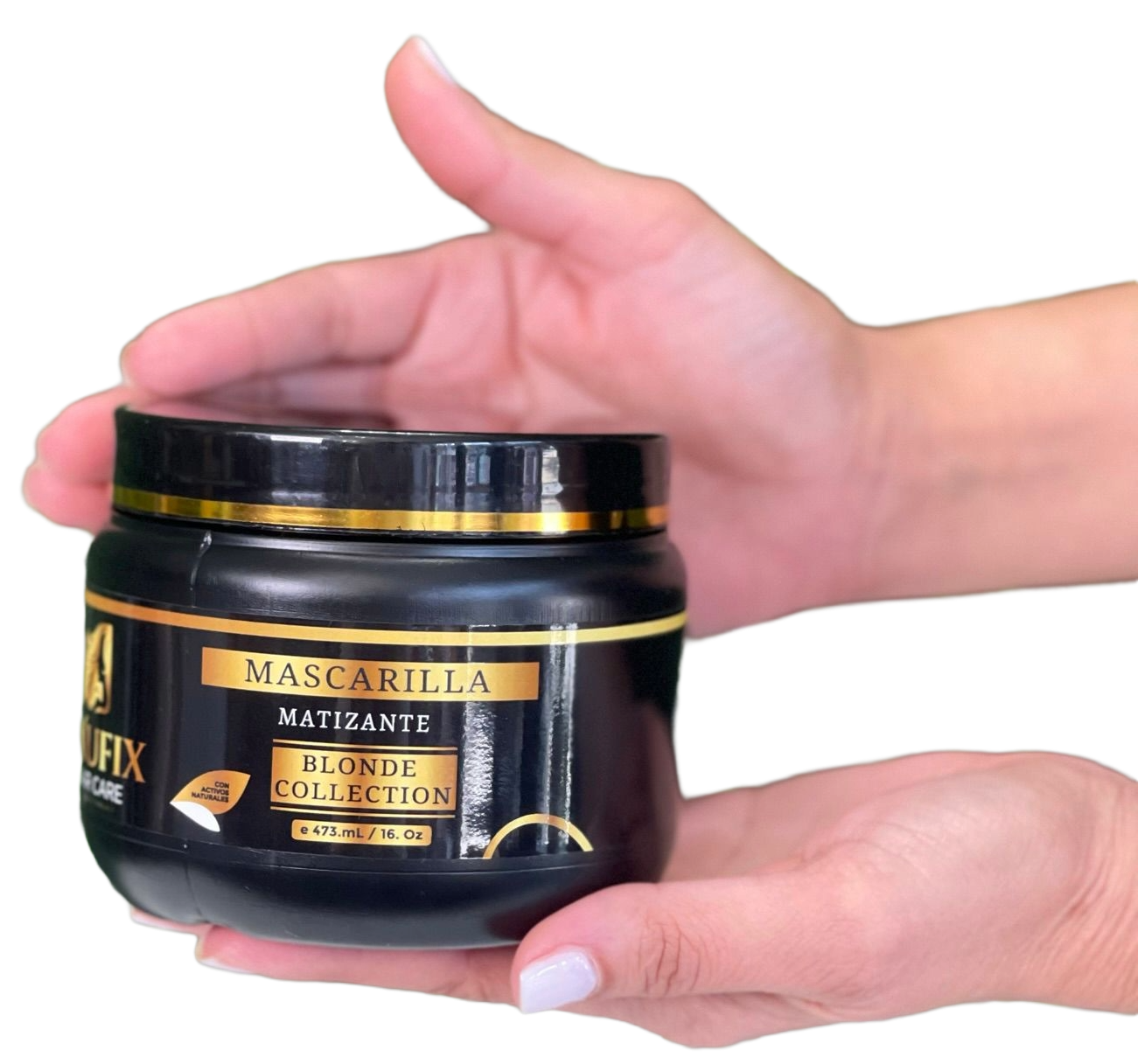 Hand holding a black jar of beauty cream labeled 'Mascarilla Matizante Blonde Collection' with a gold and black design.
