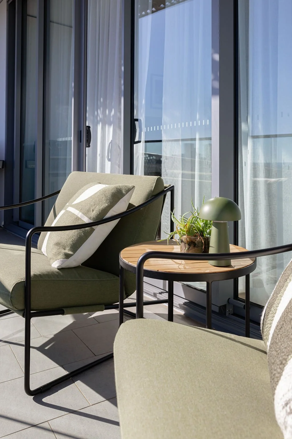 A lovely outdoor furniture setting with green cushions and black frames