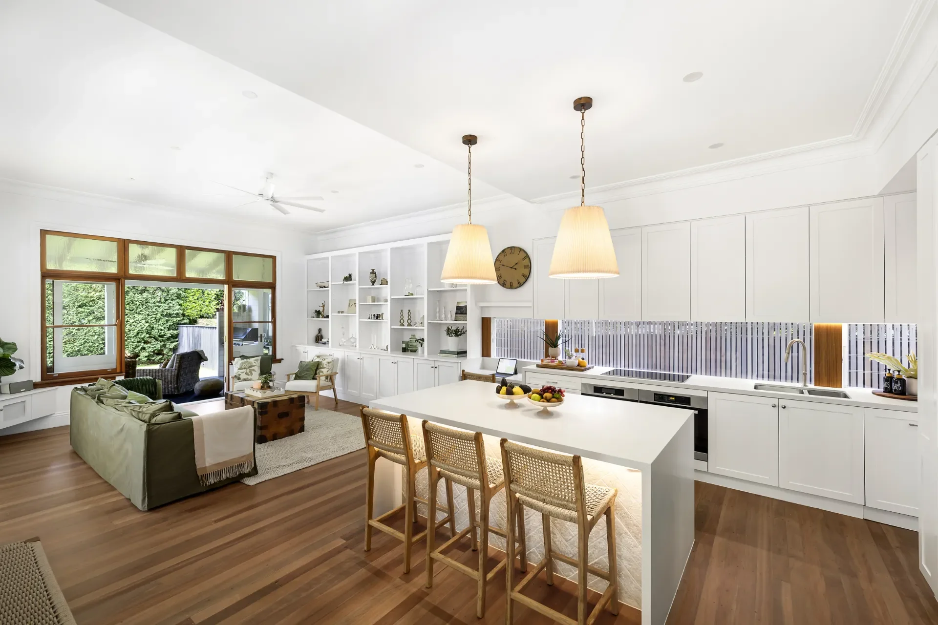 A kitchen and living space with pendant lighting over the kitchen island.