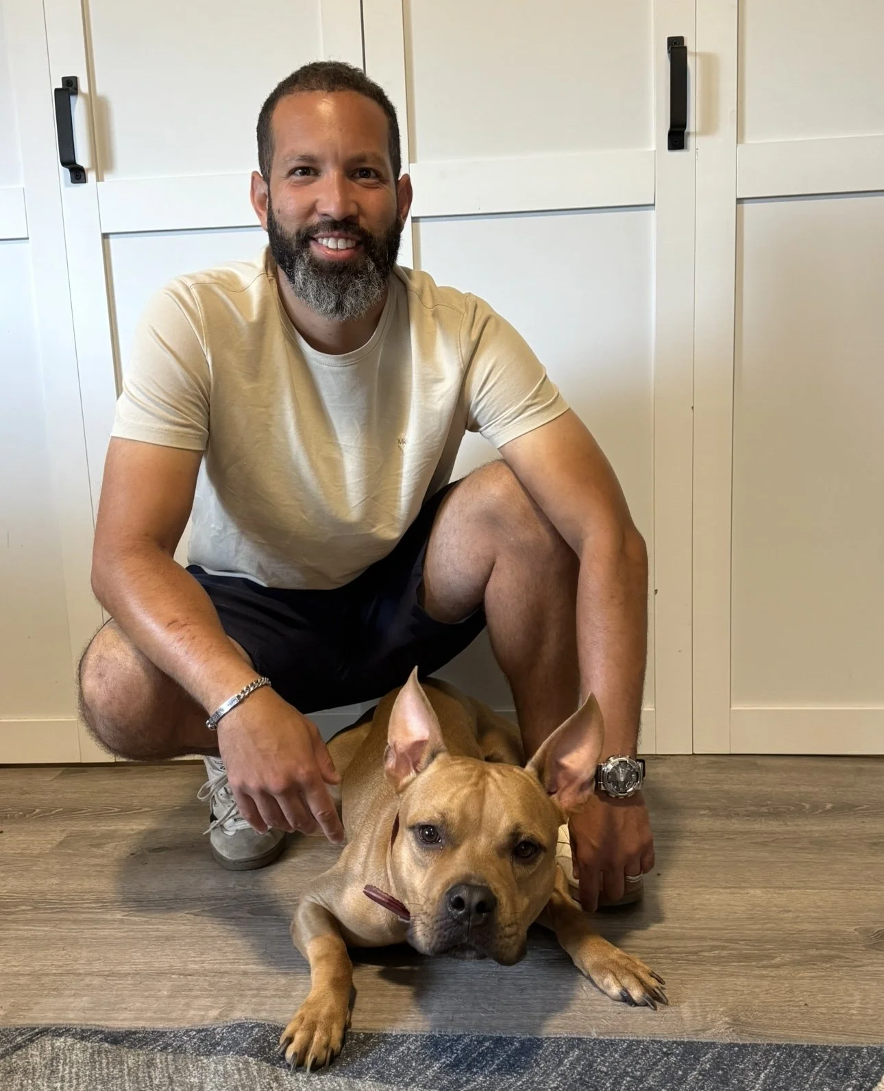 Dog trainer kneeling beside personal dog