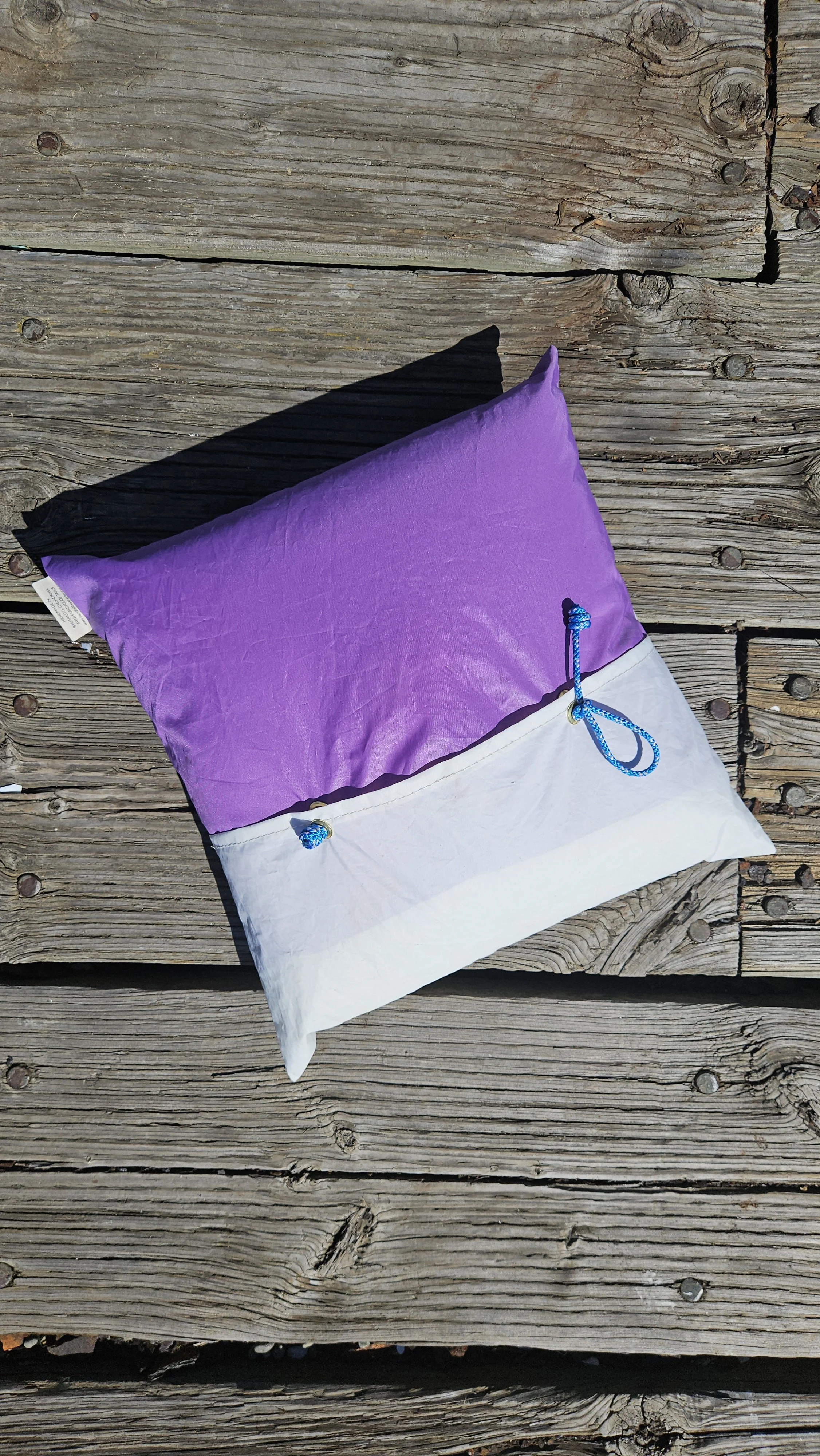Coastal patio pillow made from reclaimed sailcloth styled for outdoor living