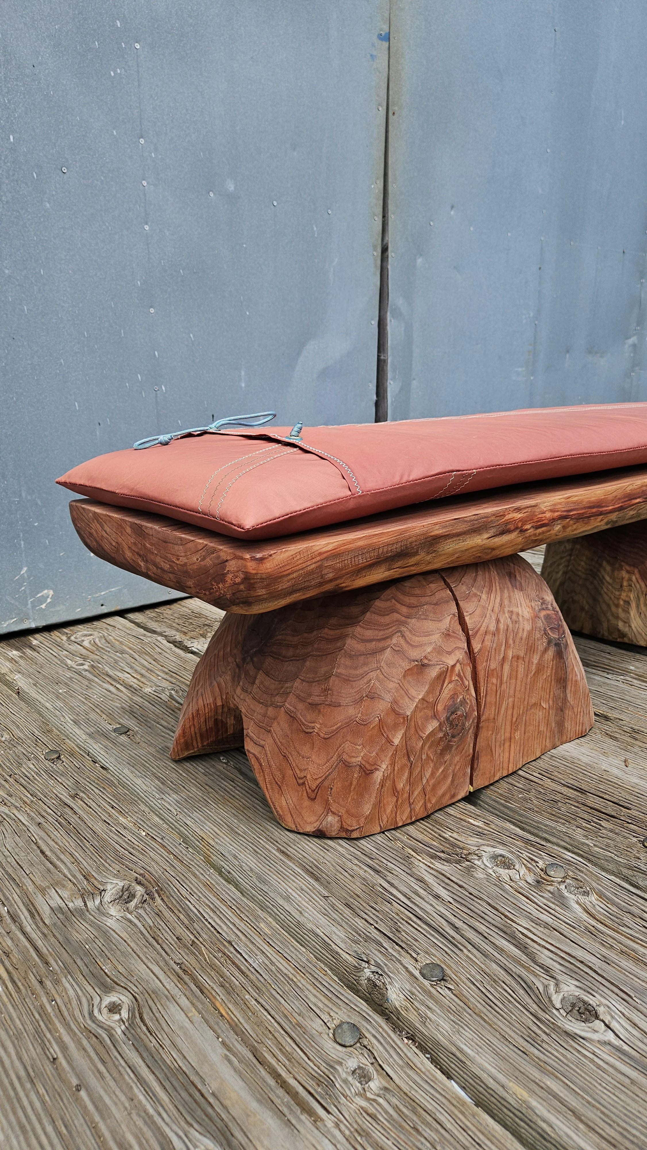 Close up of salvaged redwood bench with tanbark sail cushion