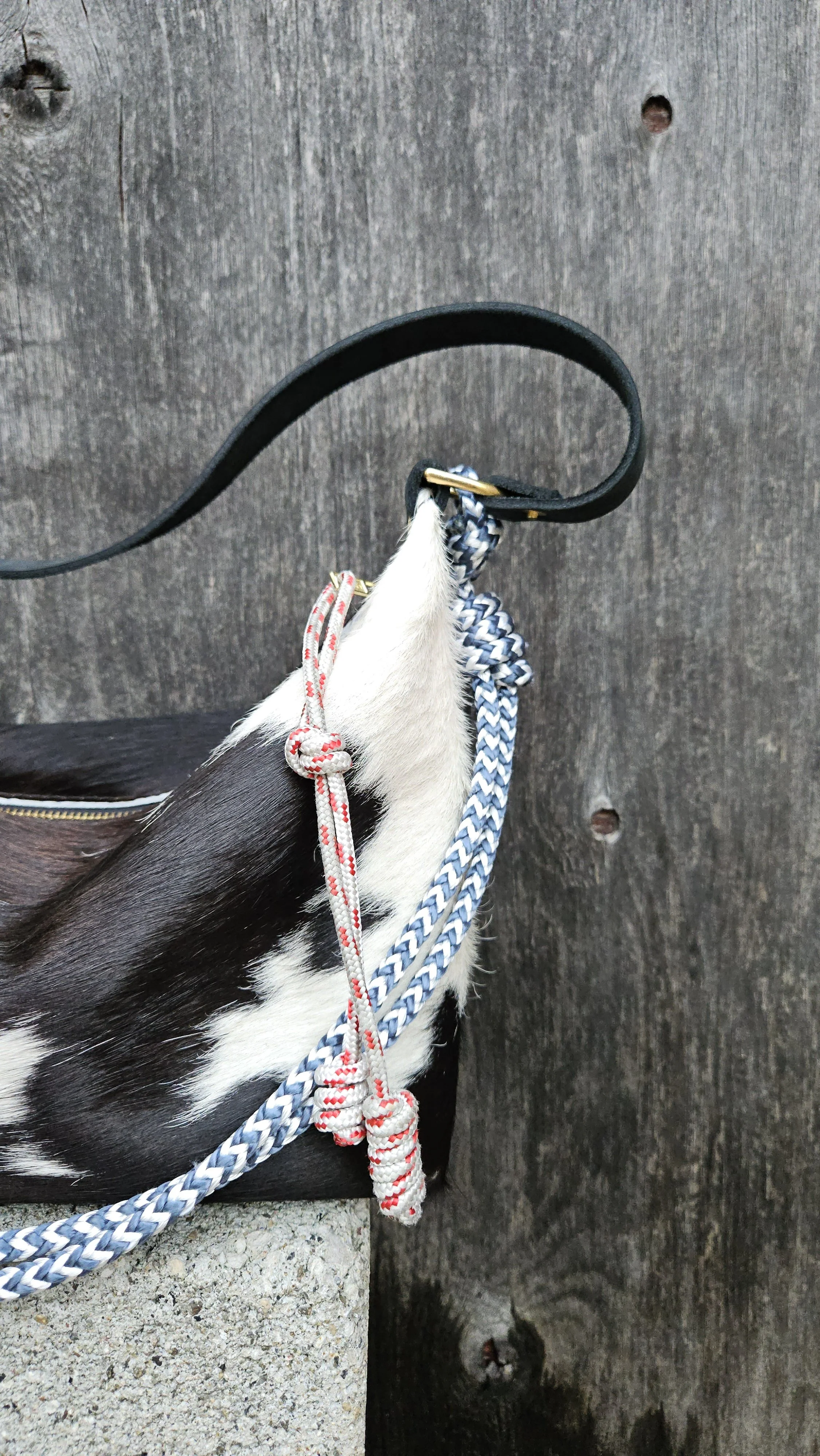 hair on cow purse with rope strap and red knotted zipper pull