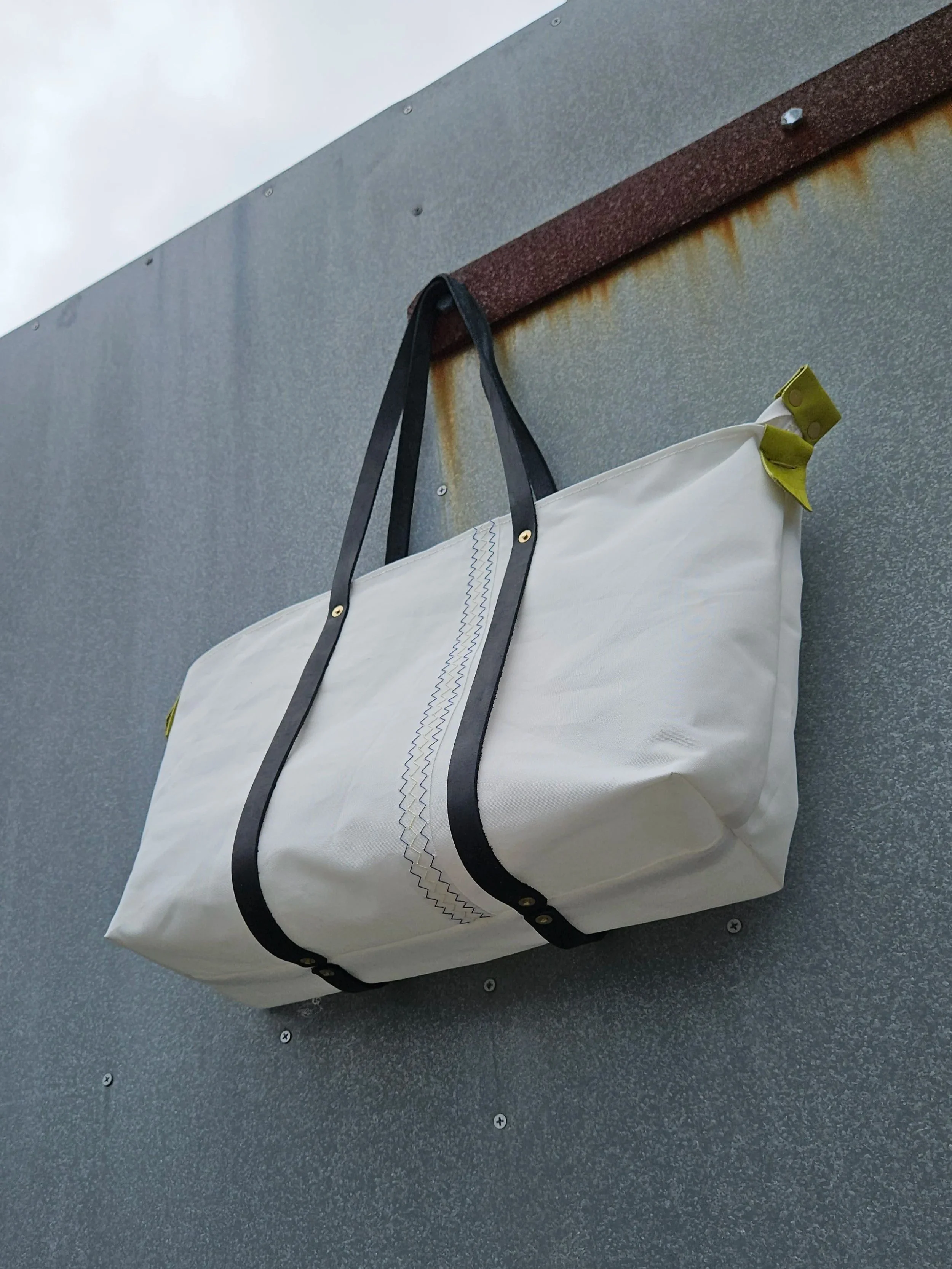 White sailcloth tote bag with black leather straps