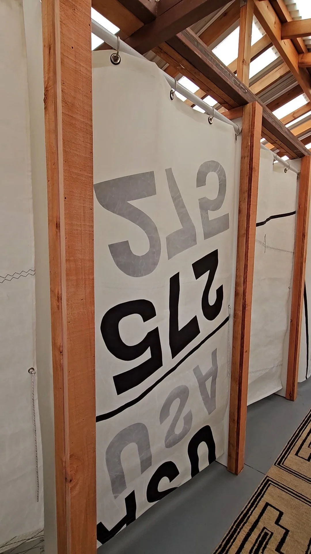 White sailcloth curtains with black numbers and stripes in Fjord sauna changing room, Sausalito, California.
